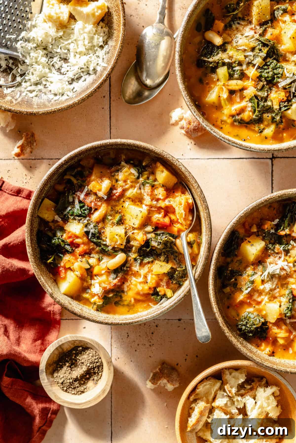 Tuscan Ribollita in three bowls. Toppings in bowls scattered around.