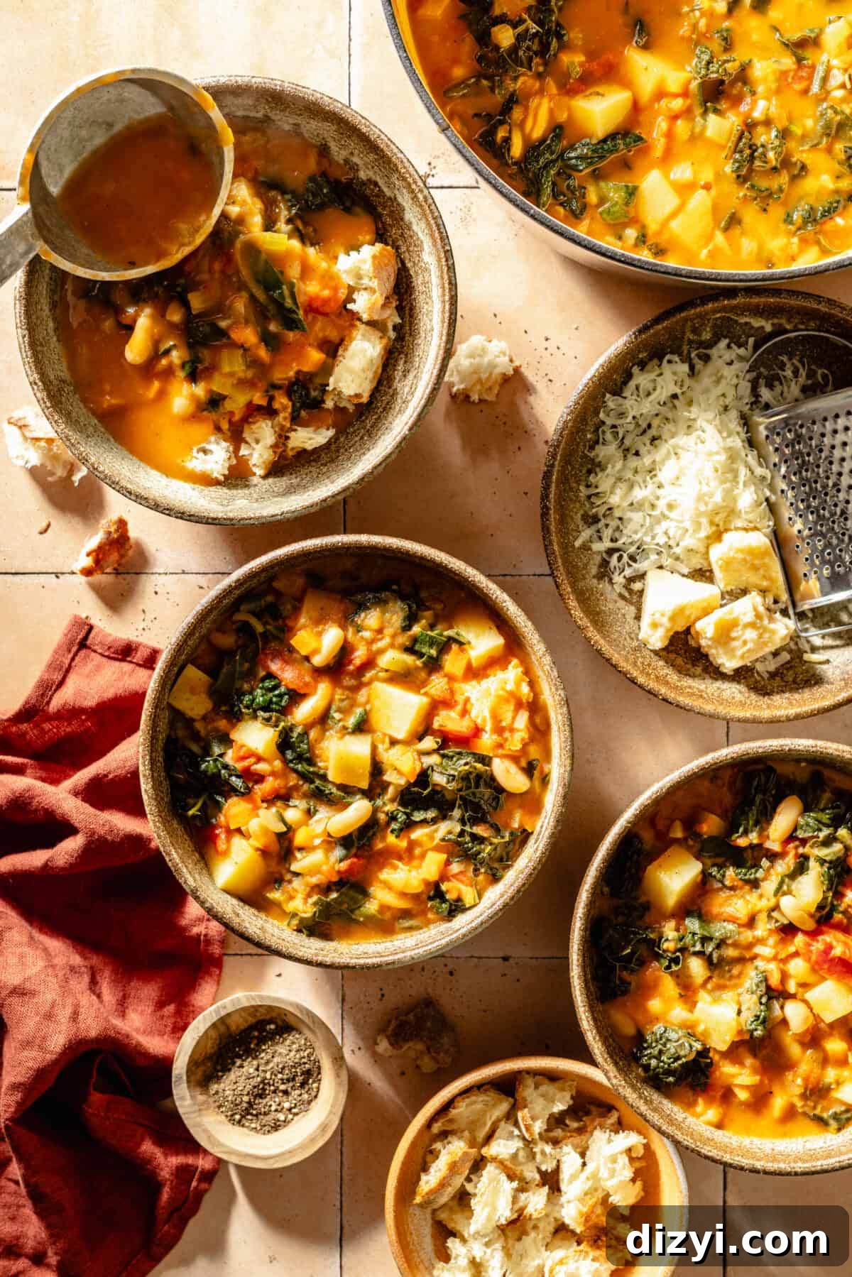 Tuscan Ribollita in three bowls. Toppings in bowls scattered around.