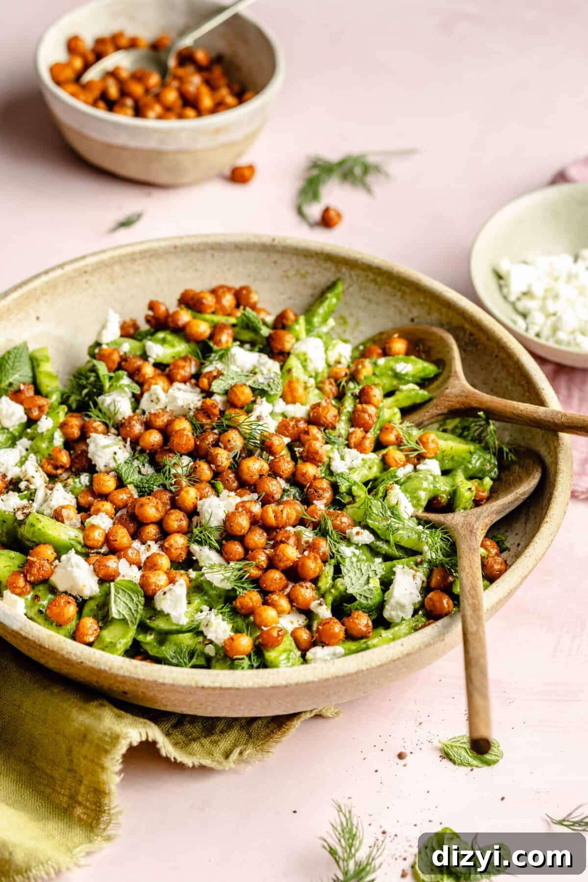 Cucumber Salad with Crispy Chickpeas in a large bowl with serving utensils.