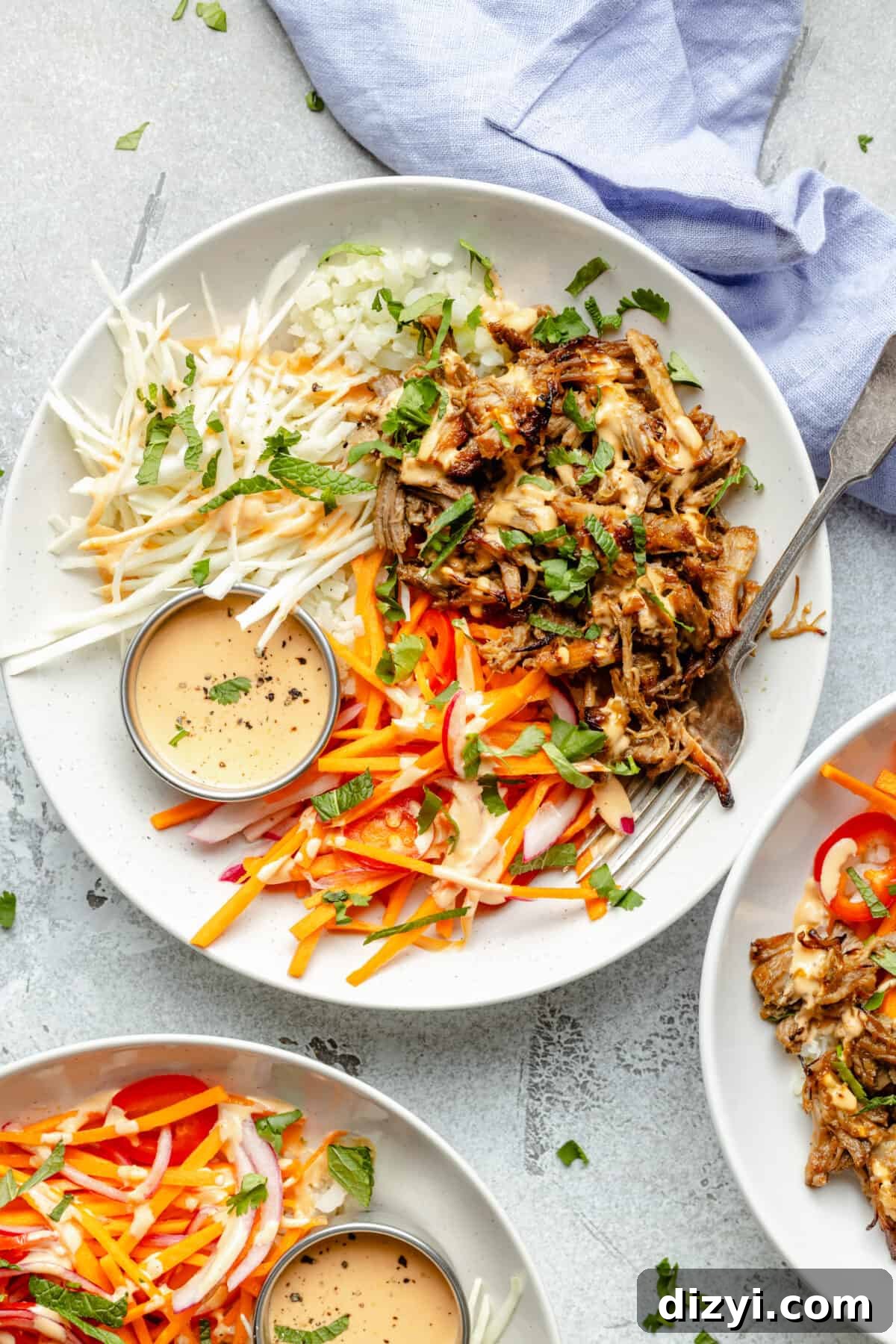 Slow Cooker Lemongrass Shredded Pork Bowls 3 Slow Cooker Shredded Lemongrass Pork Bowls in white bowls. Blue napkin ticked behind.