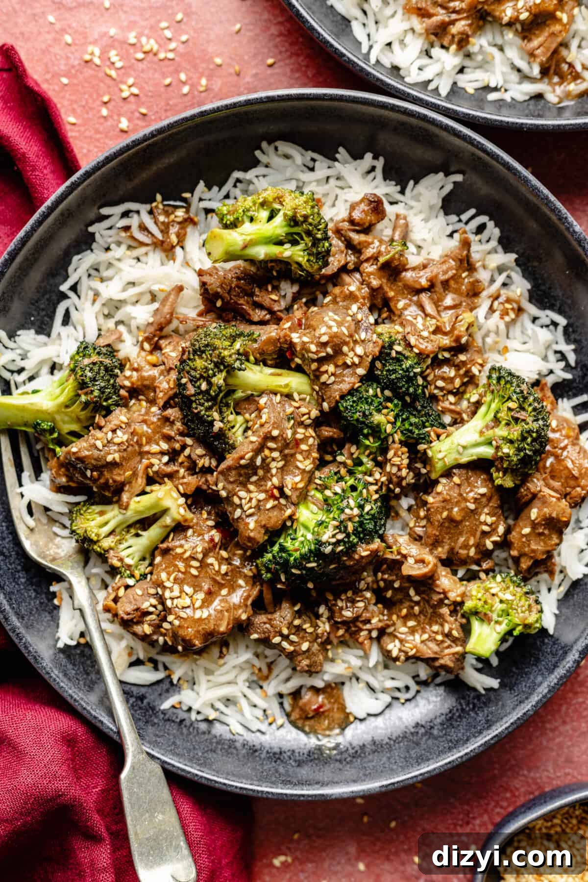 Slow Cooker Beef and Broccoli in bowls on red background.