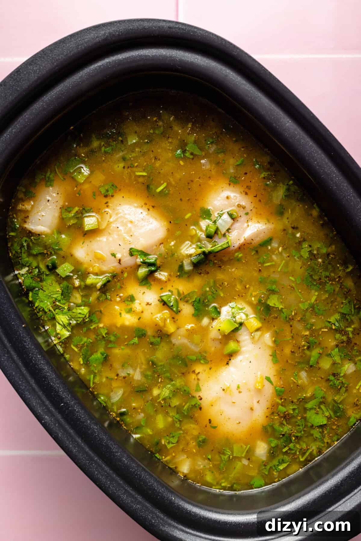 Slow Cooker Green Enchilada Chicken Soup Recipe 5 Raw chicken, broth, and other ingredients in slow cooker.