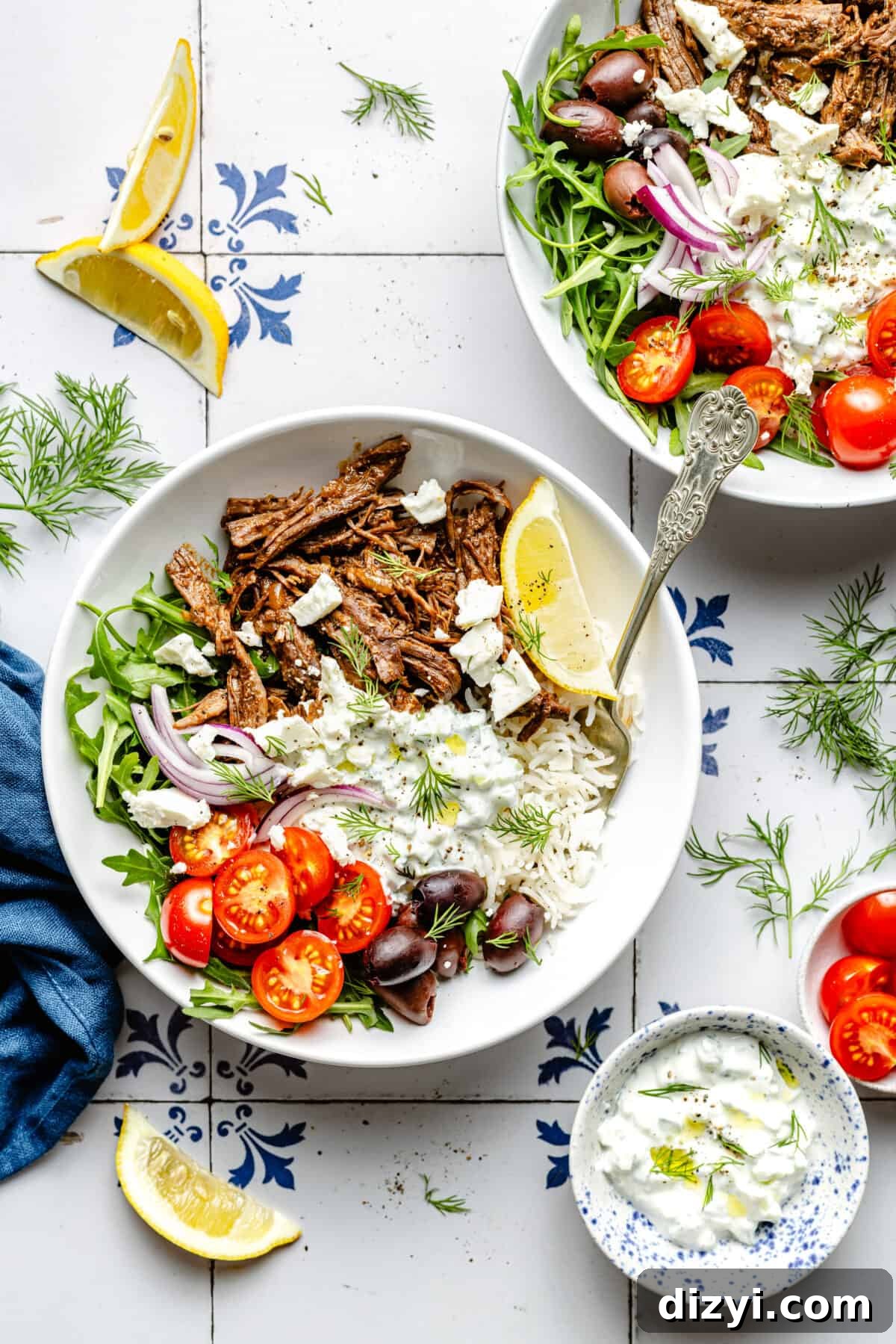 Instant Pot Greek Shredded Beef Bowls 2 Instant Pot Shredded Greek Beef in bowl with garnishes scattered around.