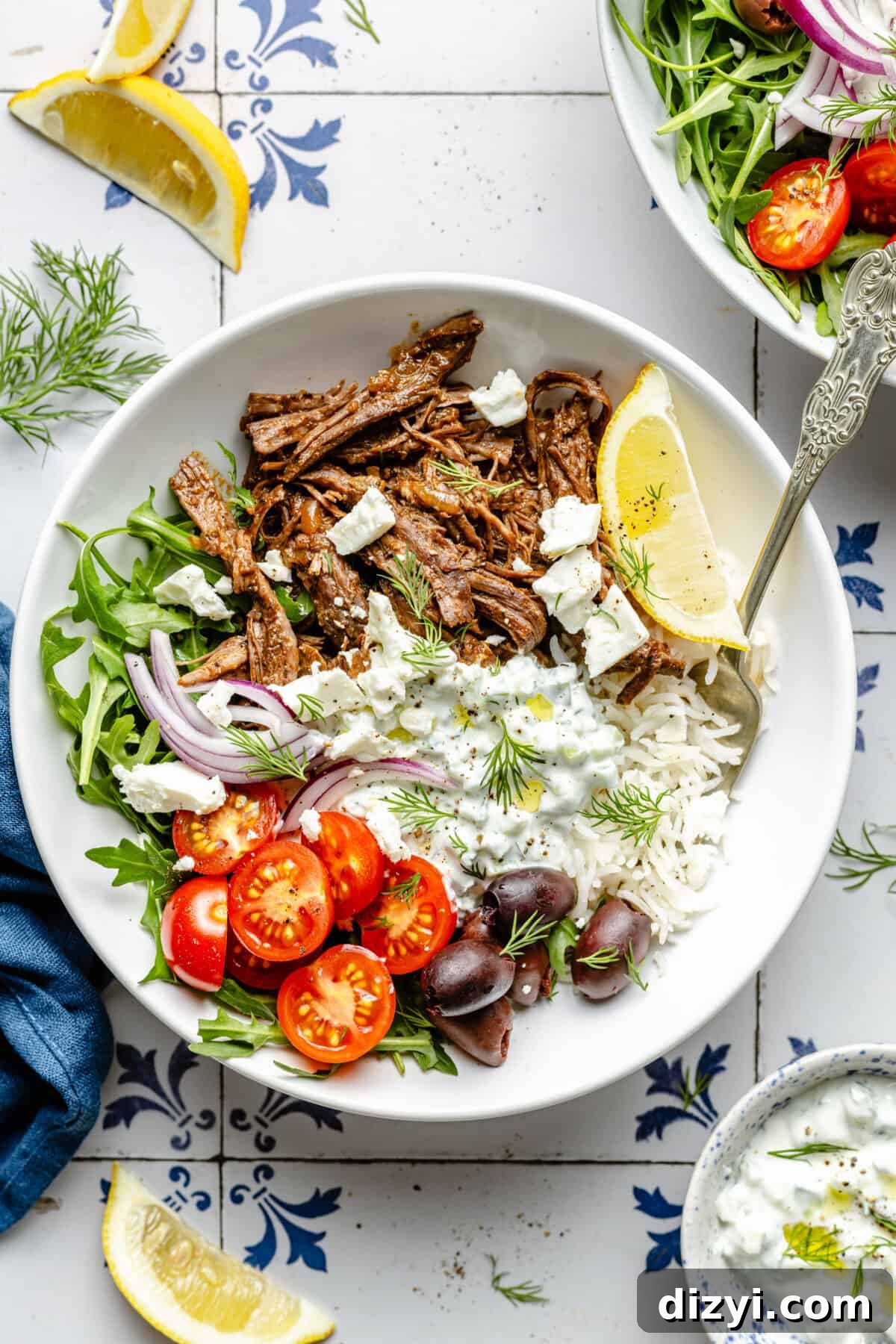 Instant Pot Greek Shredded Beef Bowls 6 Instant Pot Shredded Greek Beef in bowl with garnishes scattered around.