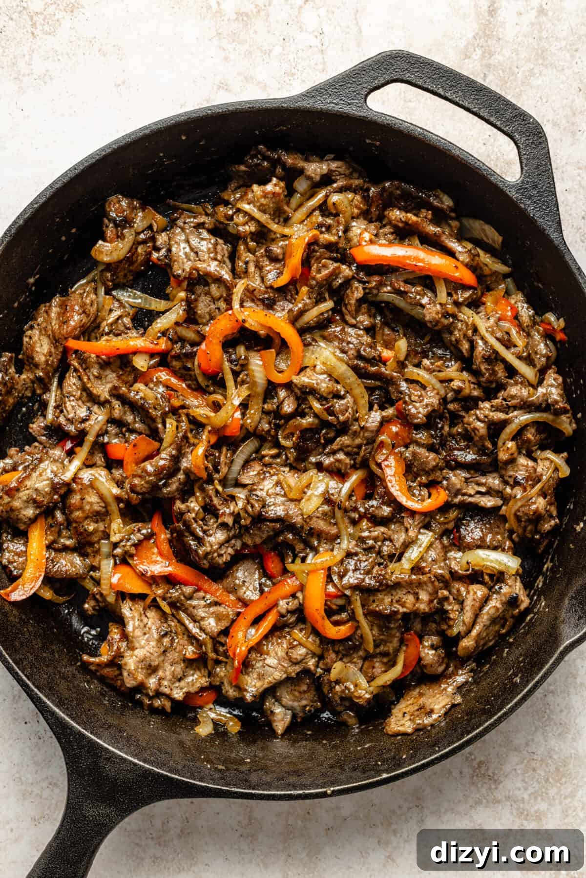 Steak and veggies cooked and in cast iron skillet.
