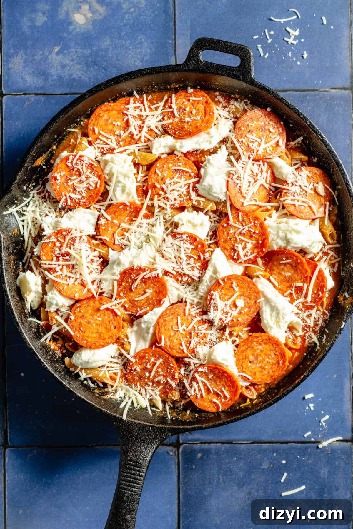 Skillet Pizza Penne: Cheesy One-Pan Pasta 5 Skillet Pizza Penne with raw pepperoni and cheese on top before cooking.