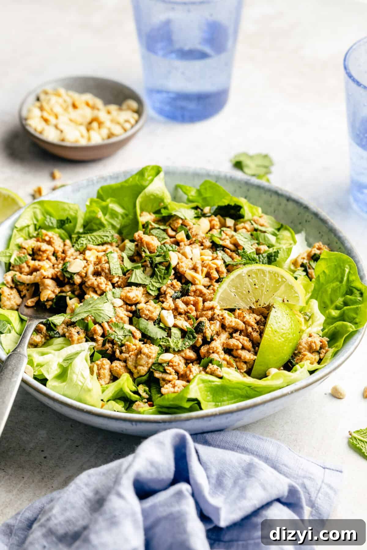 Spicy Miso Chicken Salad with Sesame Dressing 3 Spicy Miso Chicken Salad in white bowl with lime wedges.