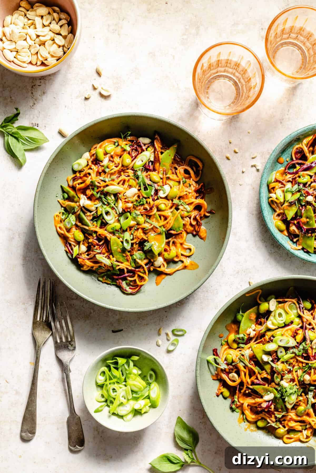 Gochujang Peanut Noodles with Crisp Vegetables 2 Gochujang and Peanut Veggie Noodles in green bowls. Pink glasses in corner.