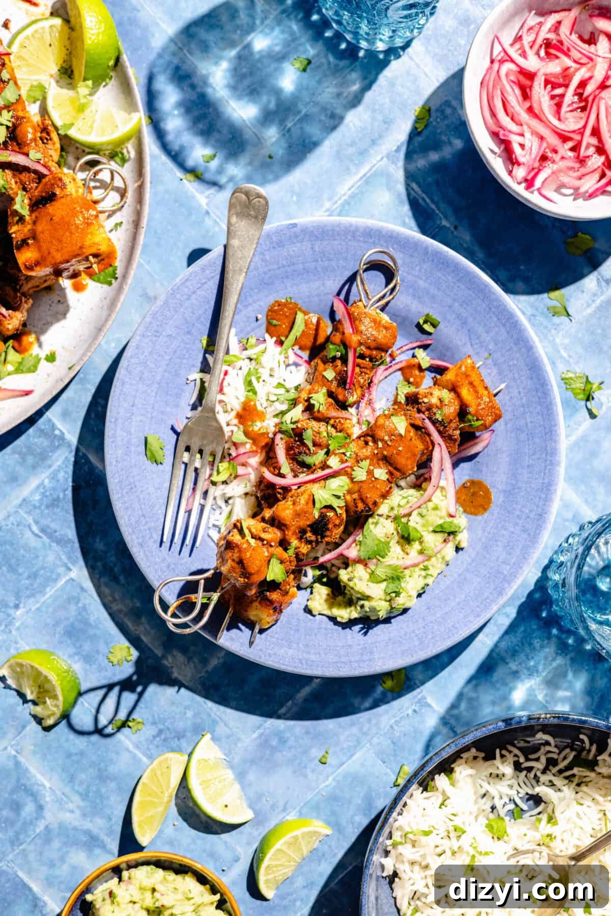 Pork Pastor Skewers plated over rice in blue bowl.