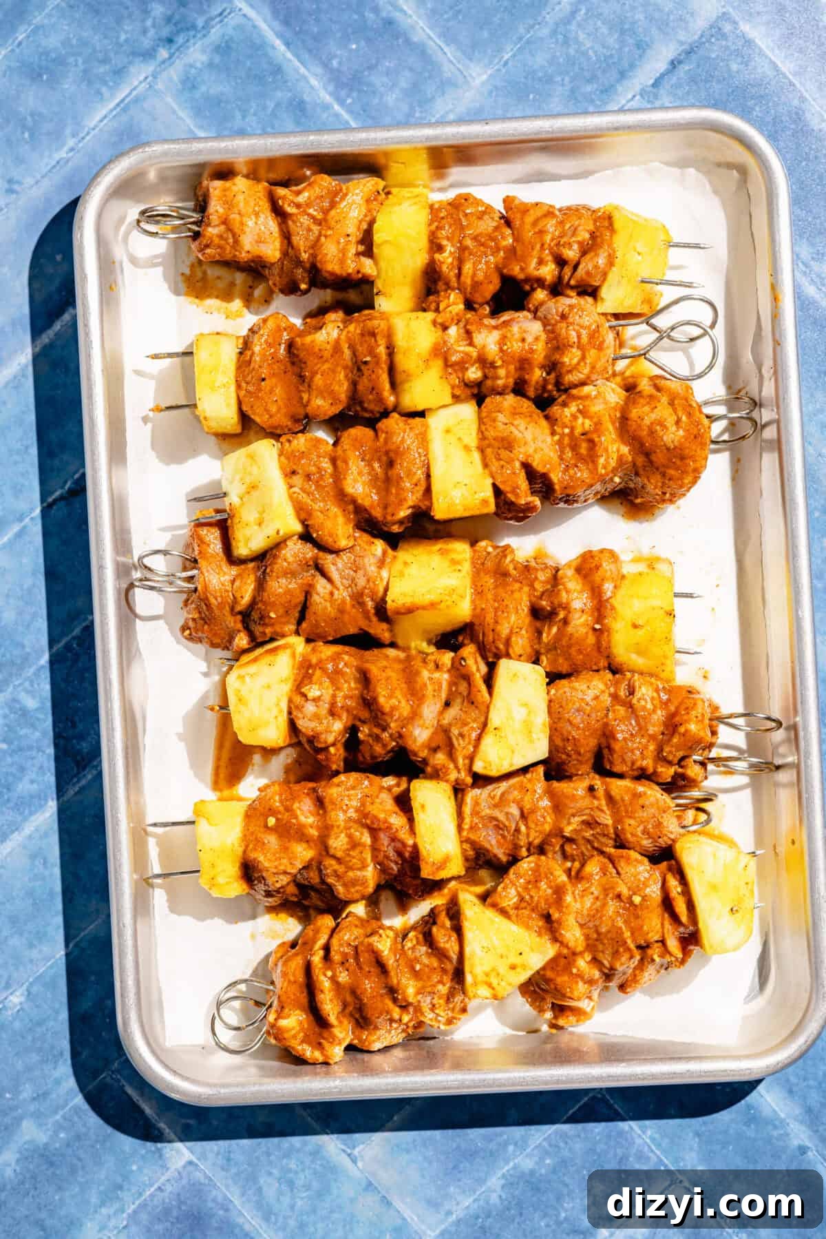 Pork Pastor Skewers assembled on sheet pan before grilling.