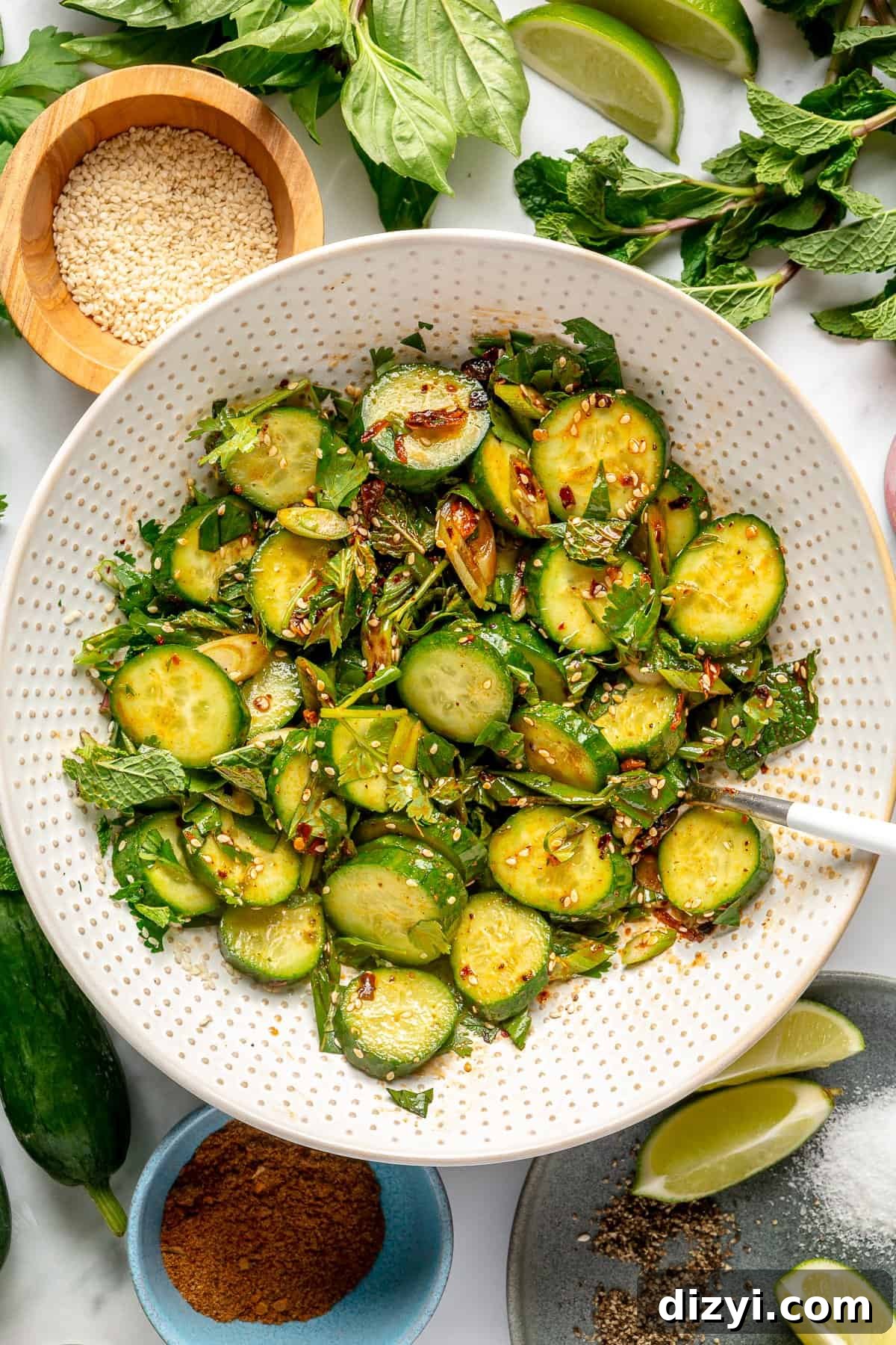 Cucumber salad assembled in large white bowl.