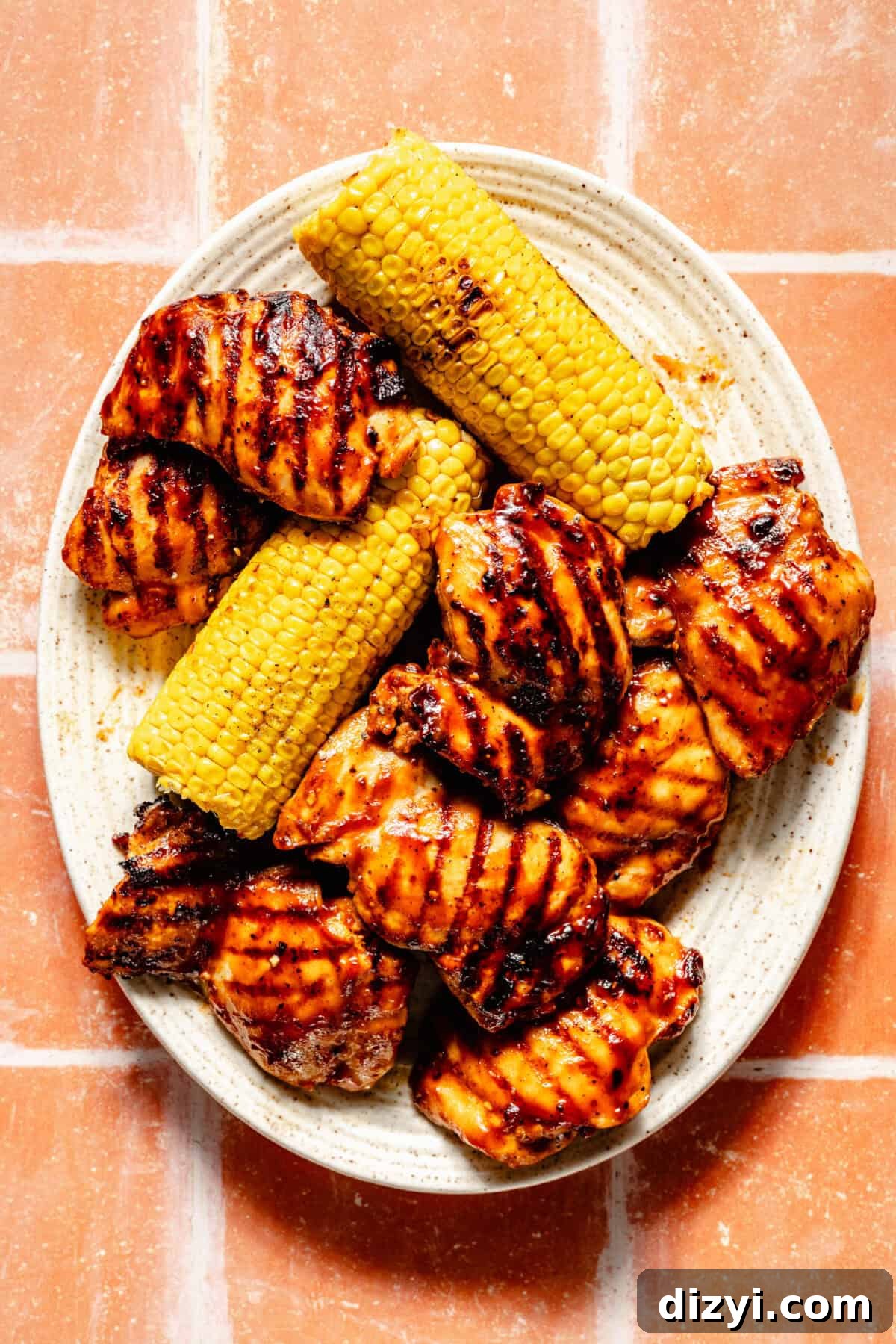 Grilled BBQ Chicken Bowls with Black Bean and Corn Salad Recipe 4 Grilled chicken and corn on large, white, oval platter.