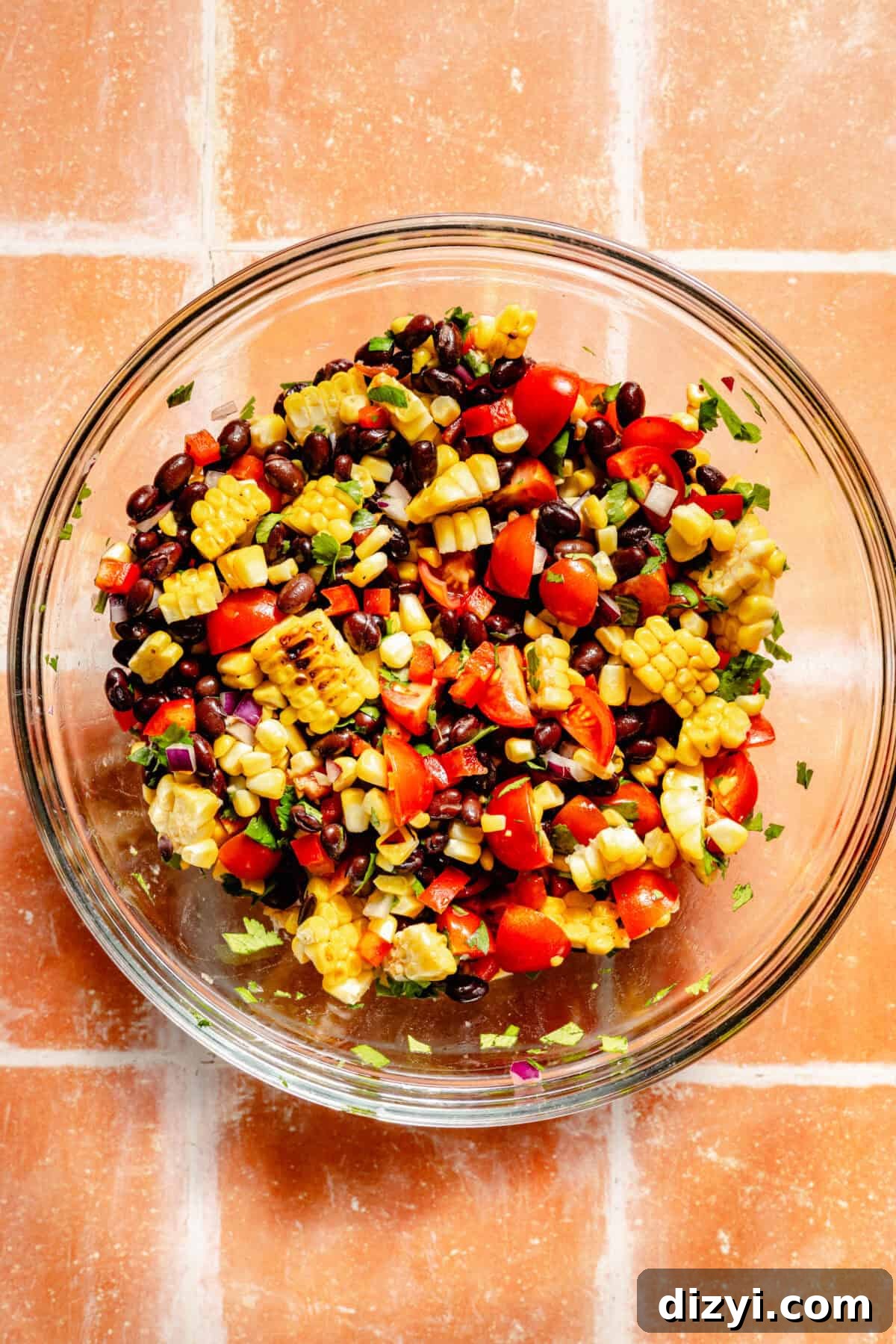 Grilled BBQ Chicken Bowls with Black Bean and Corn Salad Recipe 5 Black Bean-Corn Salad in a clear bowl on tile surface.