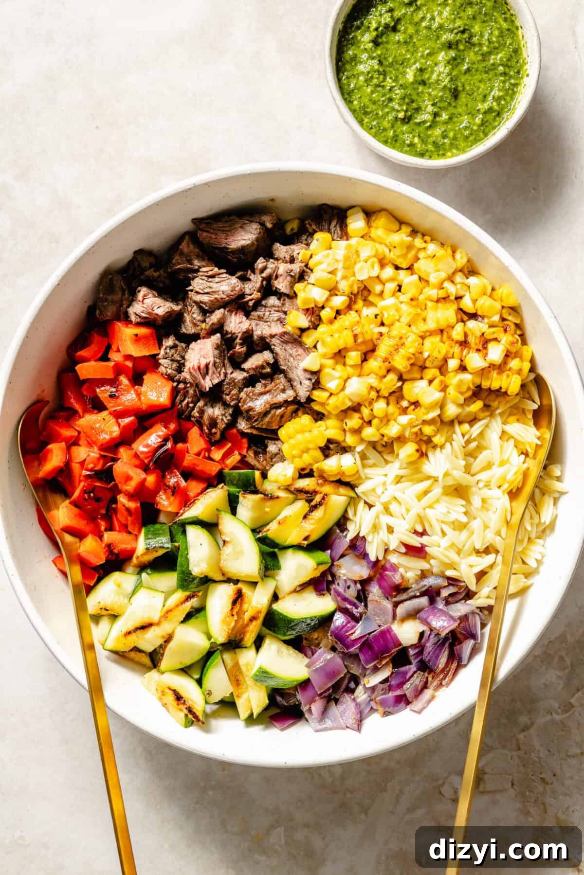 Grilled Steak and Chimichurri Pasta Salad ingredients in large bowl before it is tossed.