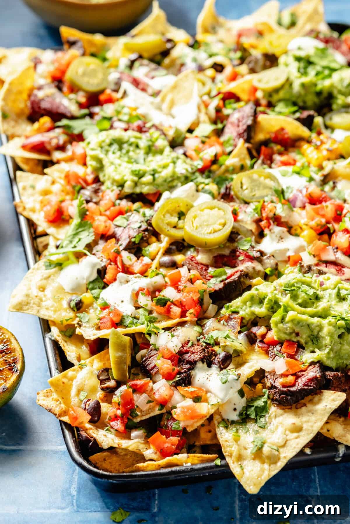 Grilled Chipotle Steak Nachos assembled on sheet pan.
