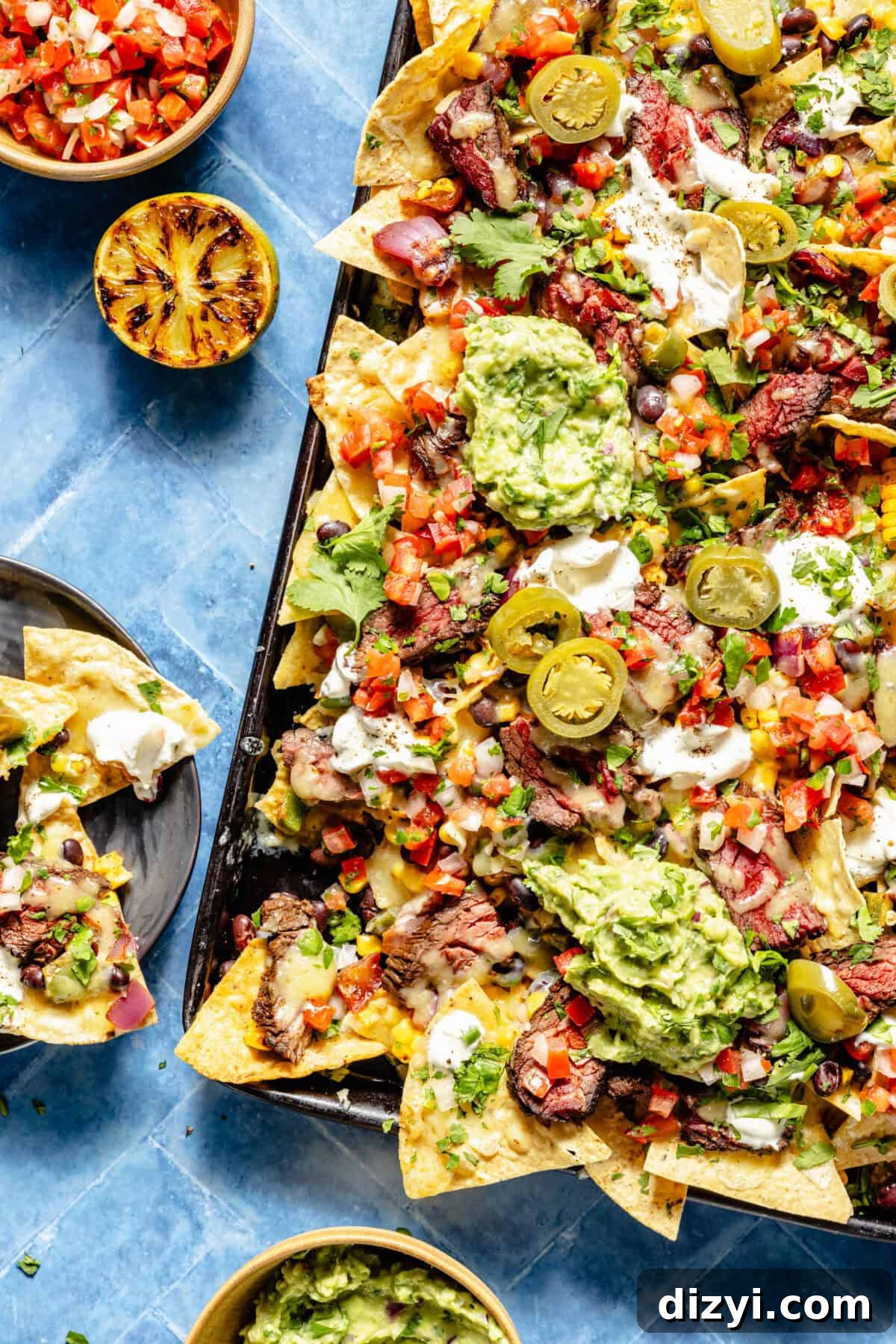Grilled Chipotle Steak Nachos assembled on sheet pan.