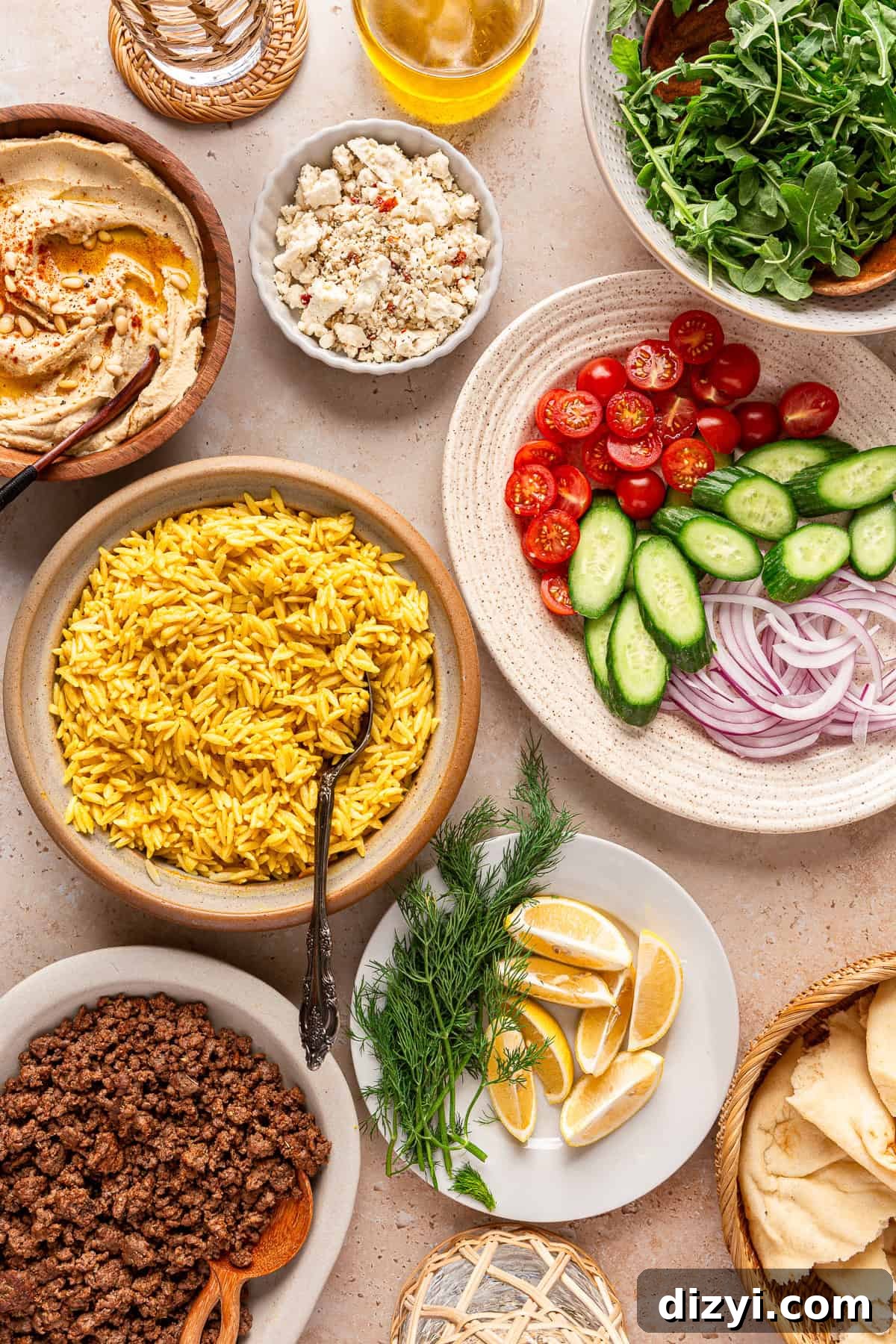The finished ingredients in various dishes on the table, ready to be used to assemble Ground Lamb Hummus Bowls.