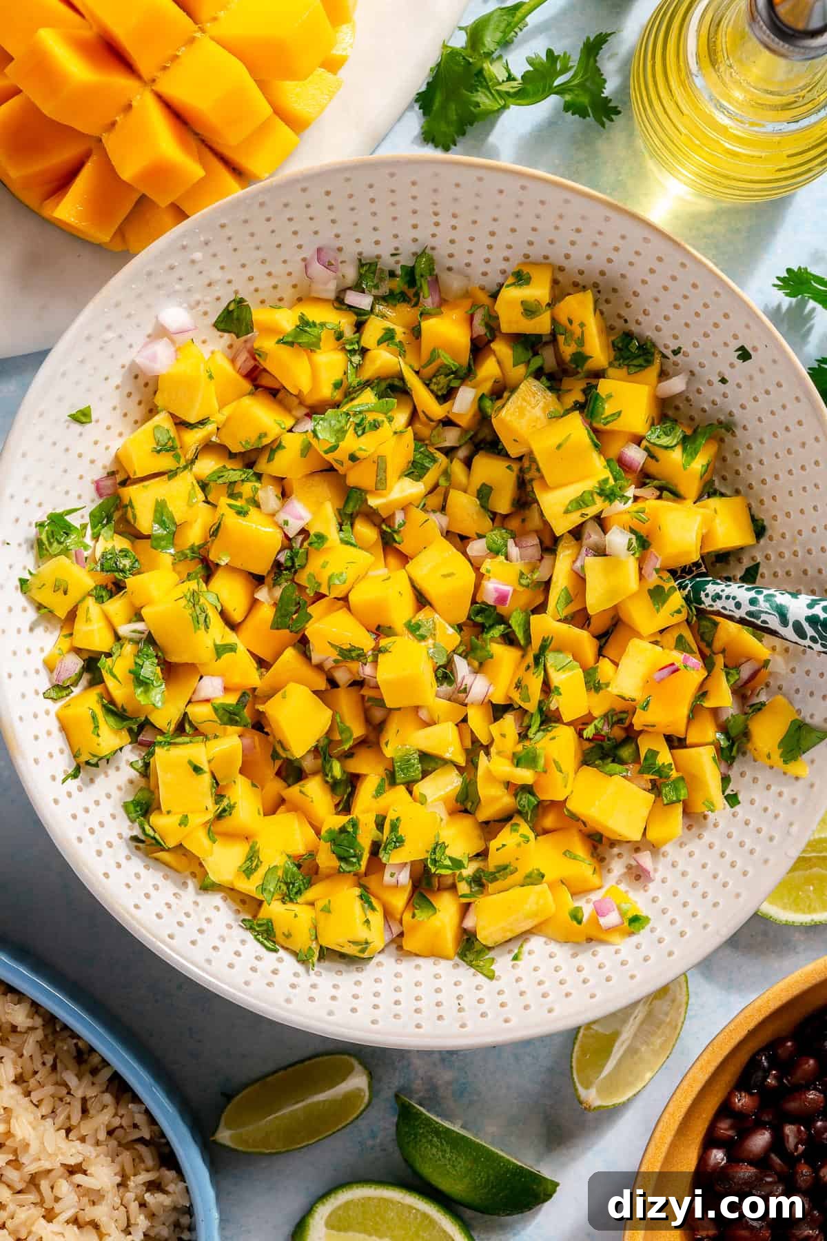 Caribbean Chicken Bowls with Jerk Seasoning and Mango Salsa 7 Quick mango salsa in a white patterned bowl, ready to be added to the Caribbean Inspired Chicken Bowls.
