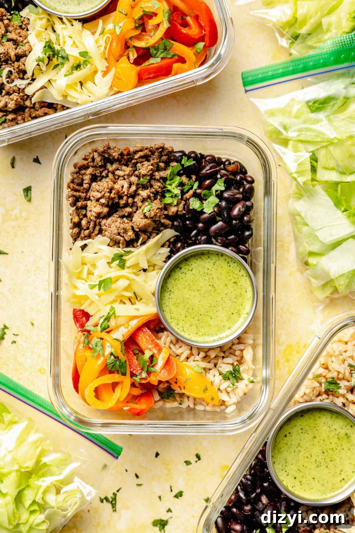 Meal-Prep Taco Bowls with Jalapeno Dressing 3 A top down photo showing meal prep containers with the Make Ahead Taco Bowls and plastic bags with the additional lettuce.