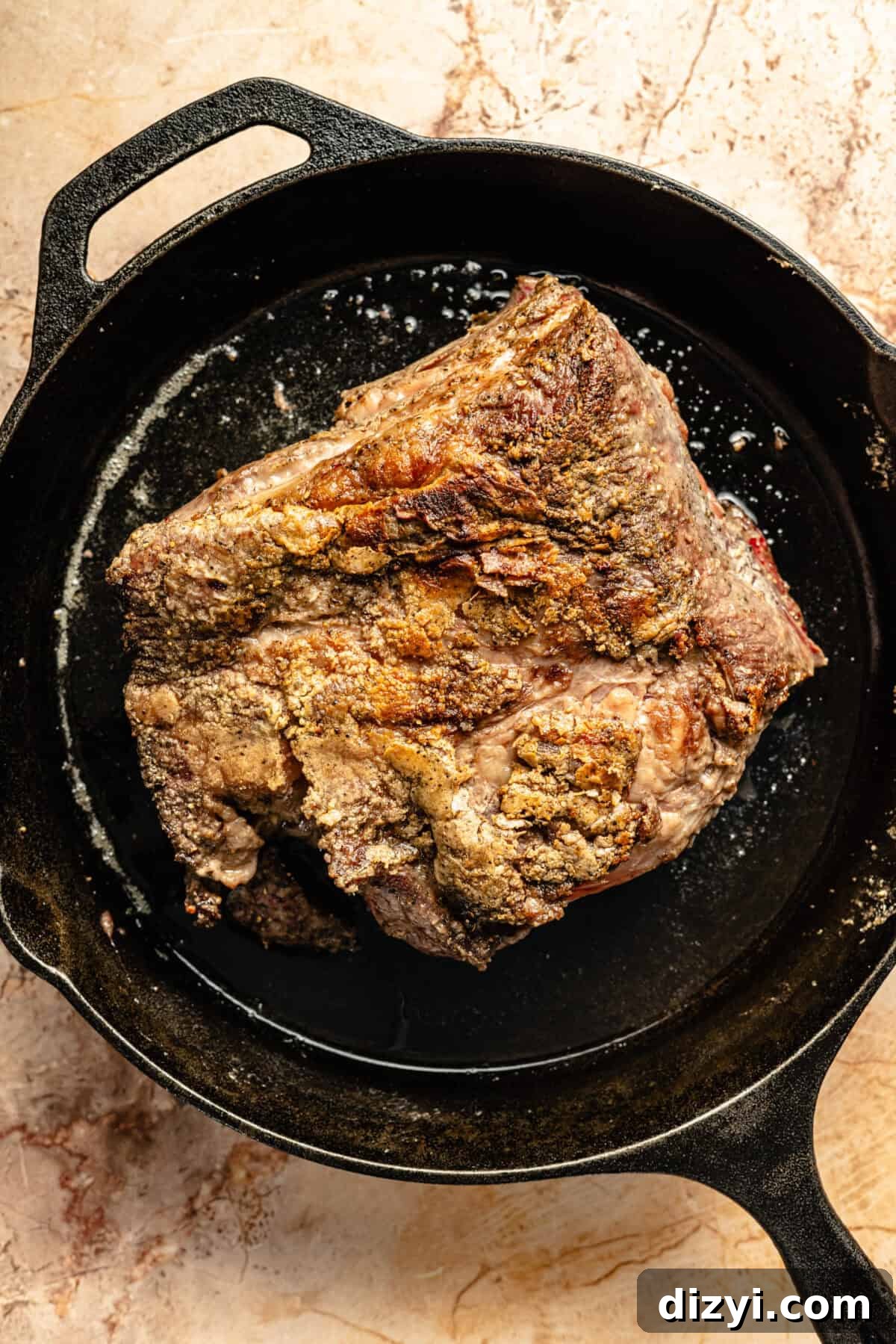 Slow Cooker Italian Shredded Beef Sliders Recipe 5 The seasoned roast for the Slow Cooker Italian Shredded Beef Sliders being browned in a cast iron skillet.