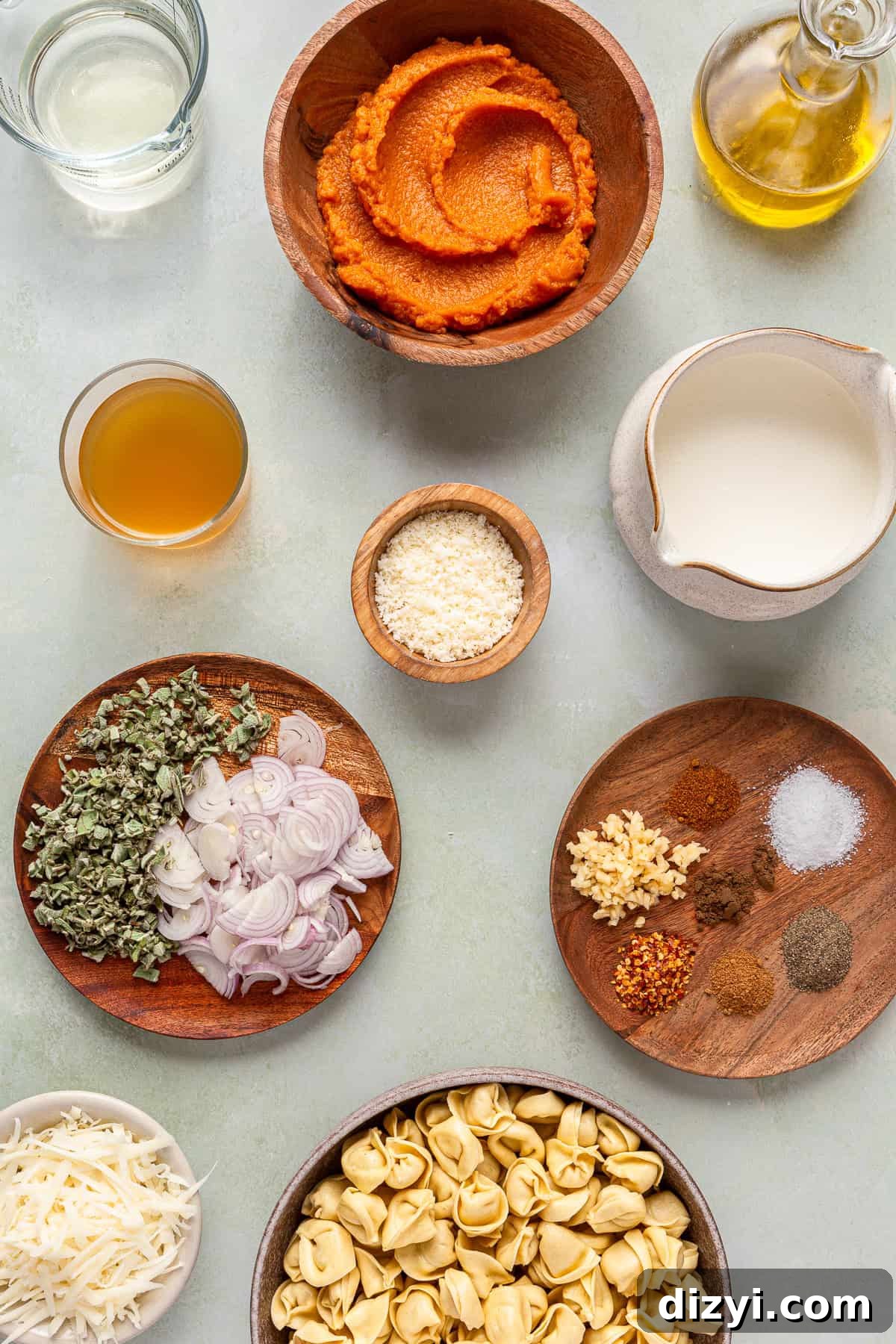 All of the ingredients for Creamy Pumpkin Tortellini, in small dishes on a light gray countertop.