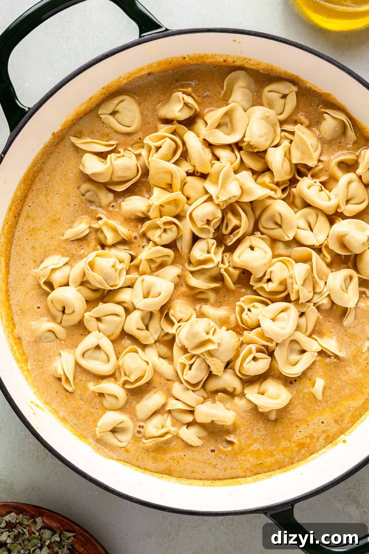 The tortellini being added to the sauce to make the Creamy Pumpkin Tortellini.