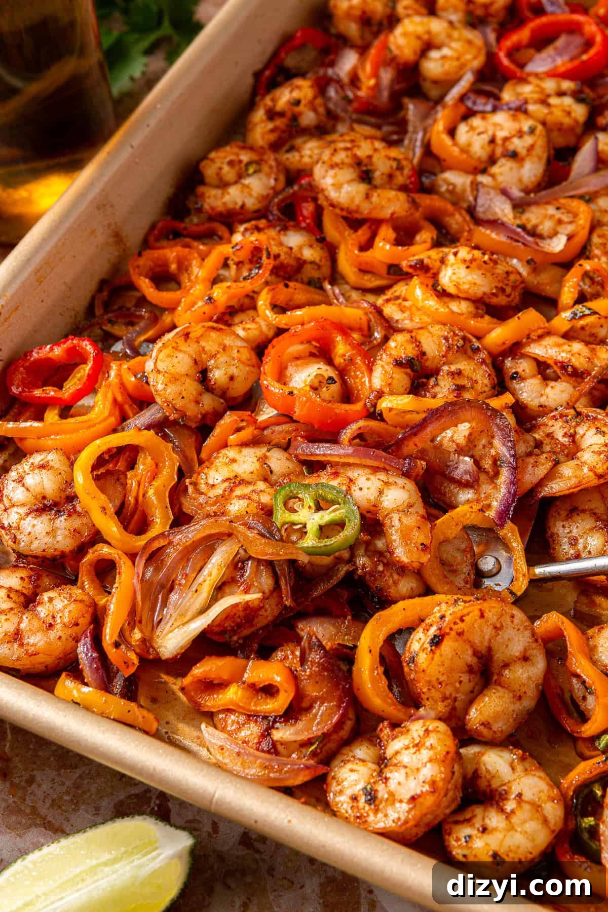 The seasoned shrimp and veggies on a sheet pan ready to go into the oven.