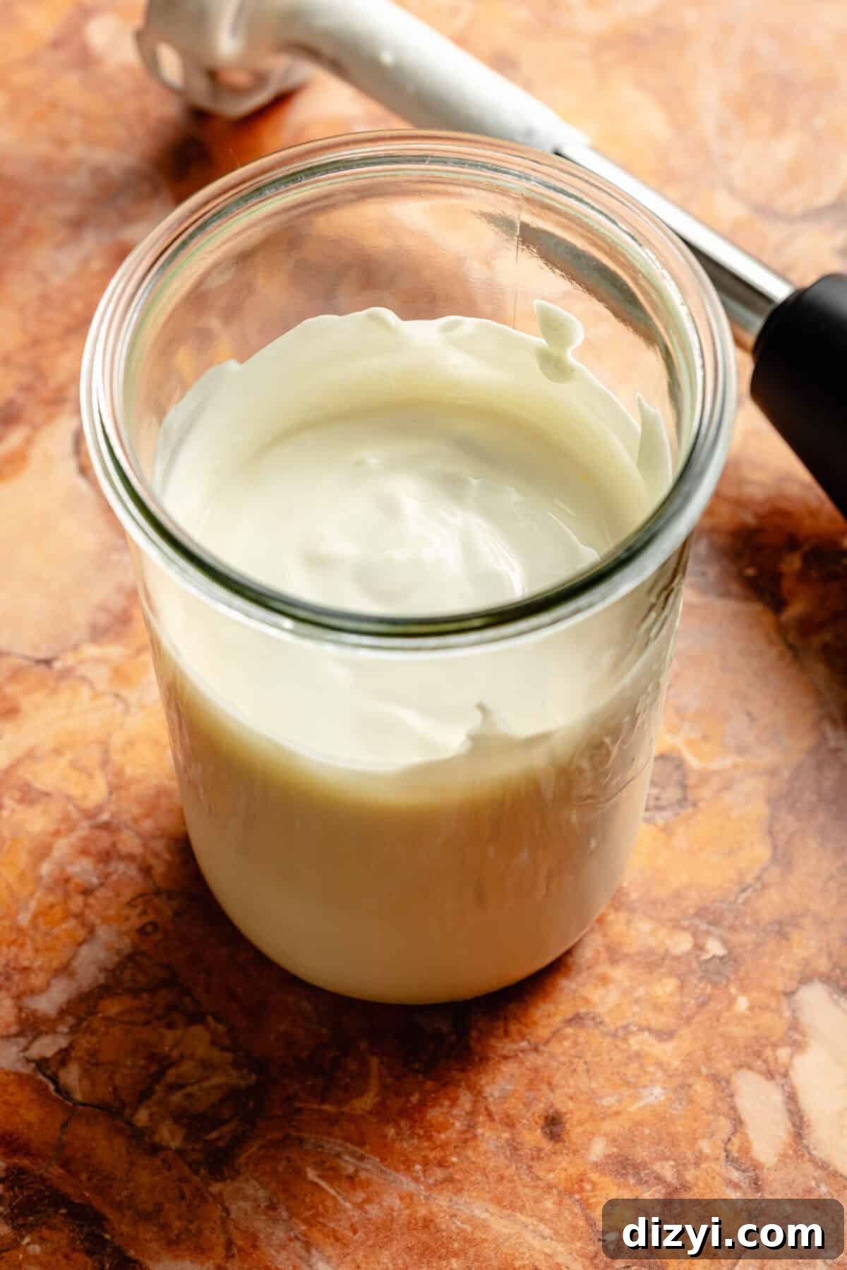 The cottage cheese and Greek yogurt blended together in a wide mouth mason jar on an orange countertop.