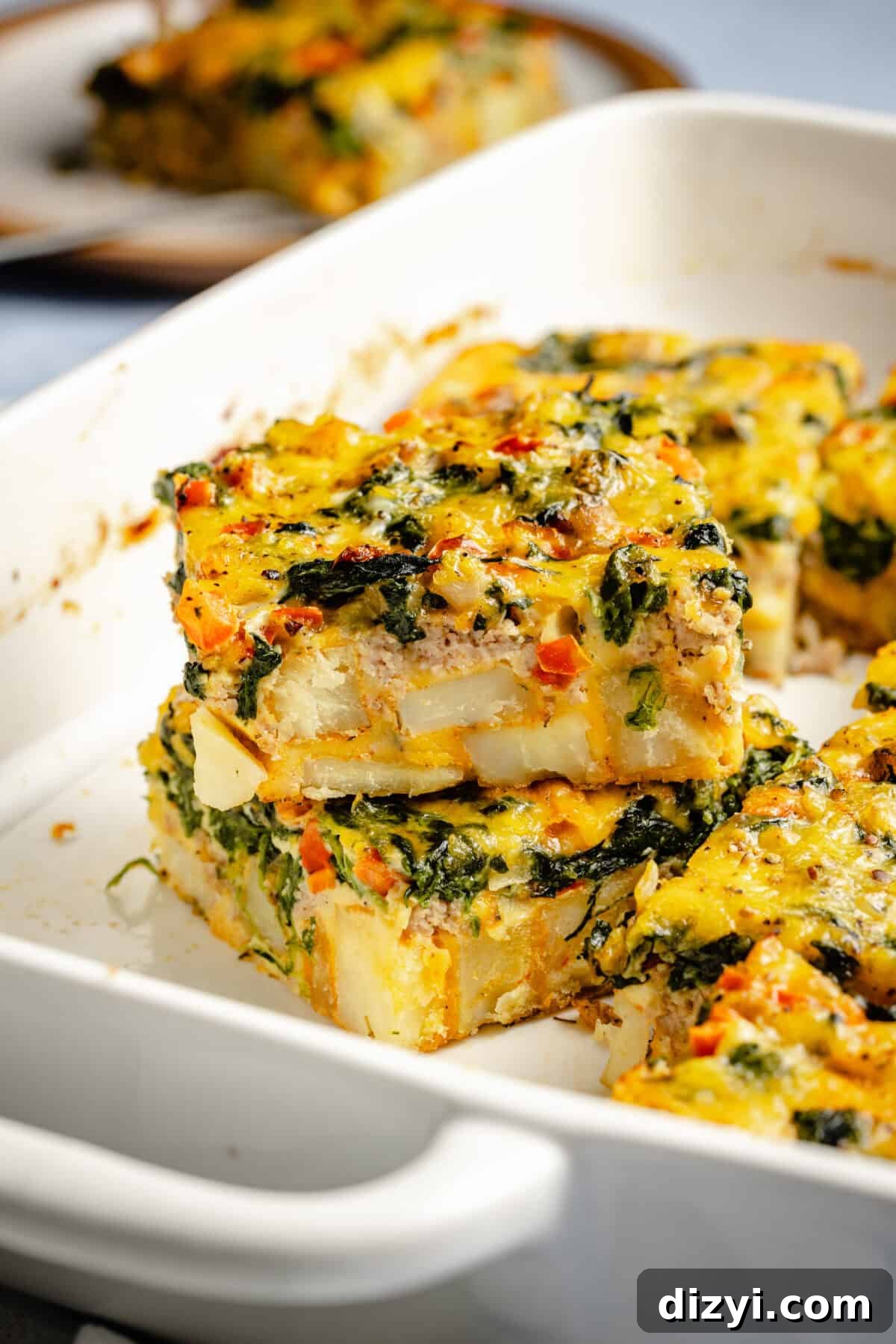 Classic Old Fashioned Breakfast Casserole Recipe 3 Two slices of Old Fashioned Breakfast Casserole stacked on top of each other in the white casserole dish.