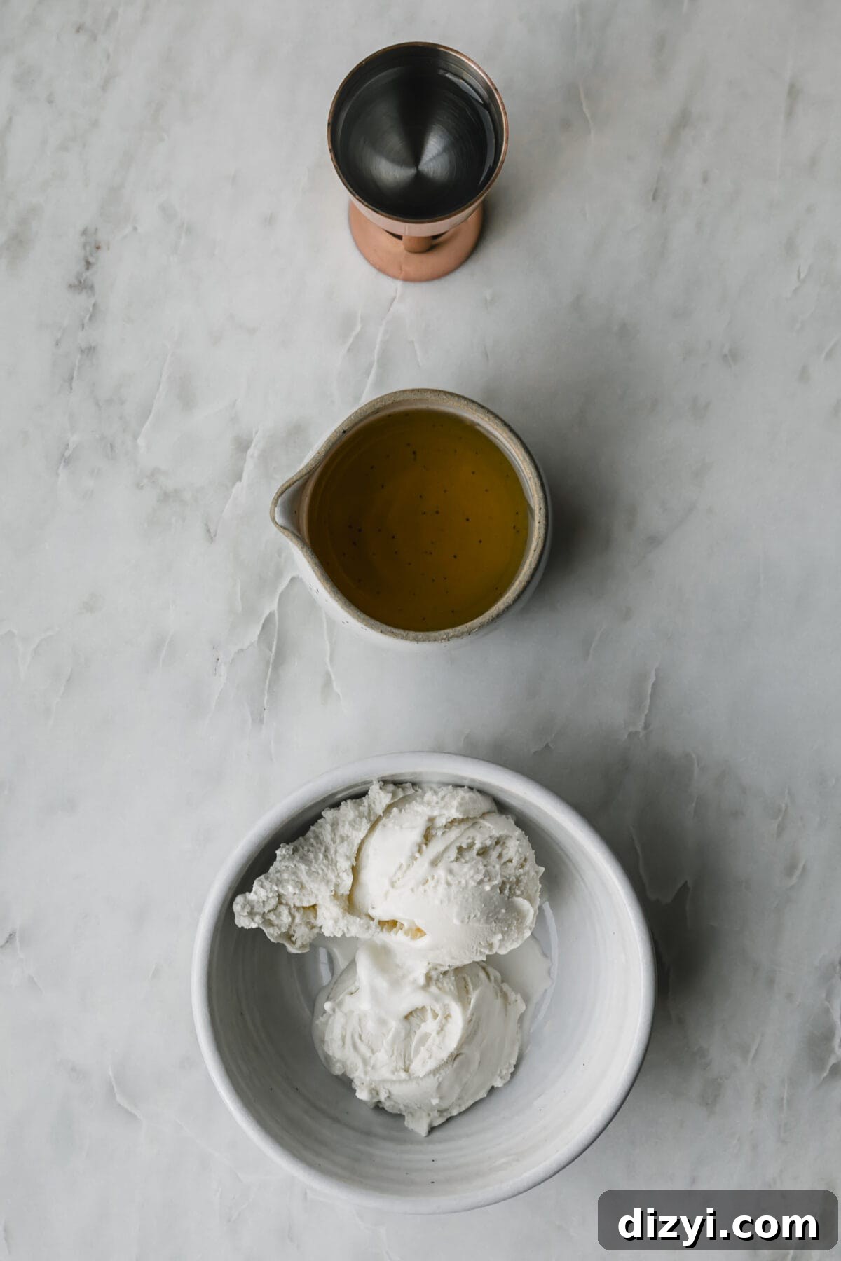 The three simple ingredients needed for Brandy Freeze Cocktail on a marble countertop.