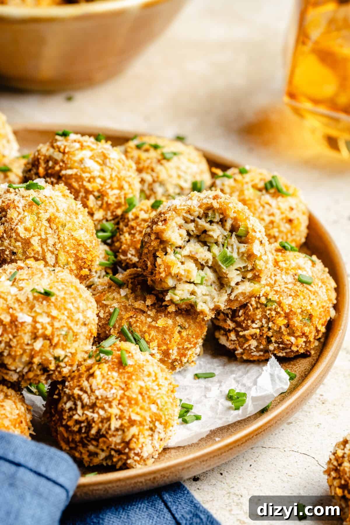 A finished plate of Crispy Crab Cake Bites, garnished with chives.