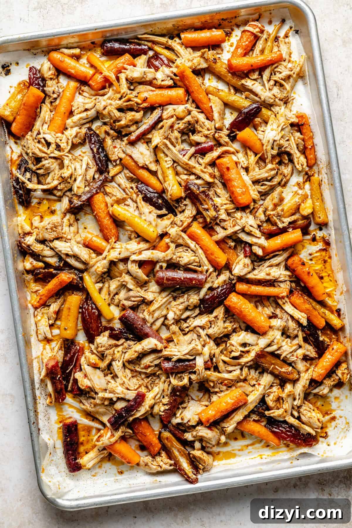 A sheet pan with roasted carrots, chicken, and dates.
