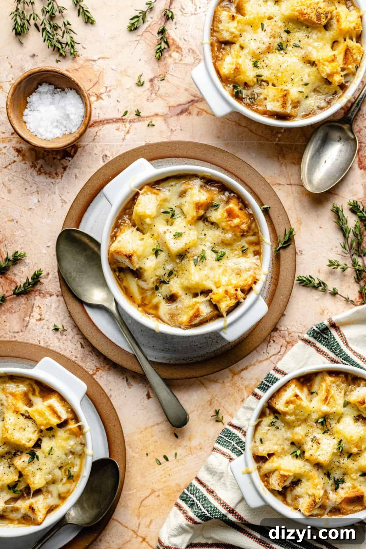Four bowls of French Onion Soup with melted cheese on top.