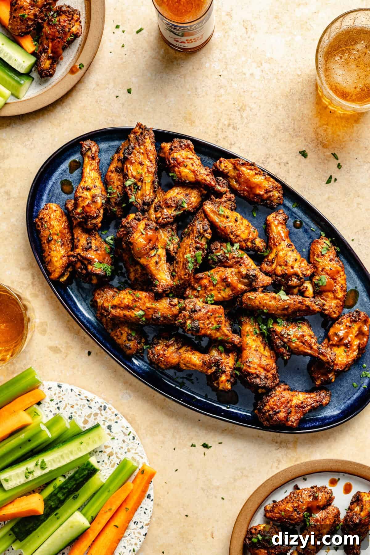 Cajun Spiced Chicken Wings on blue oval platter. Beer and cute veggies on the side.