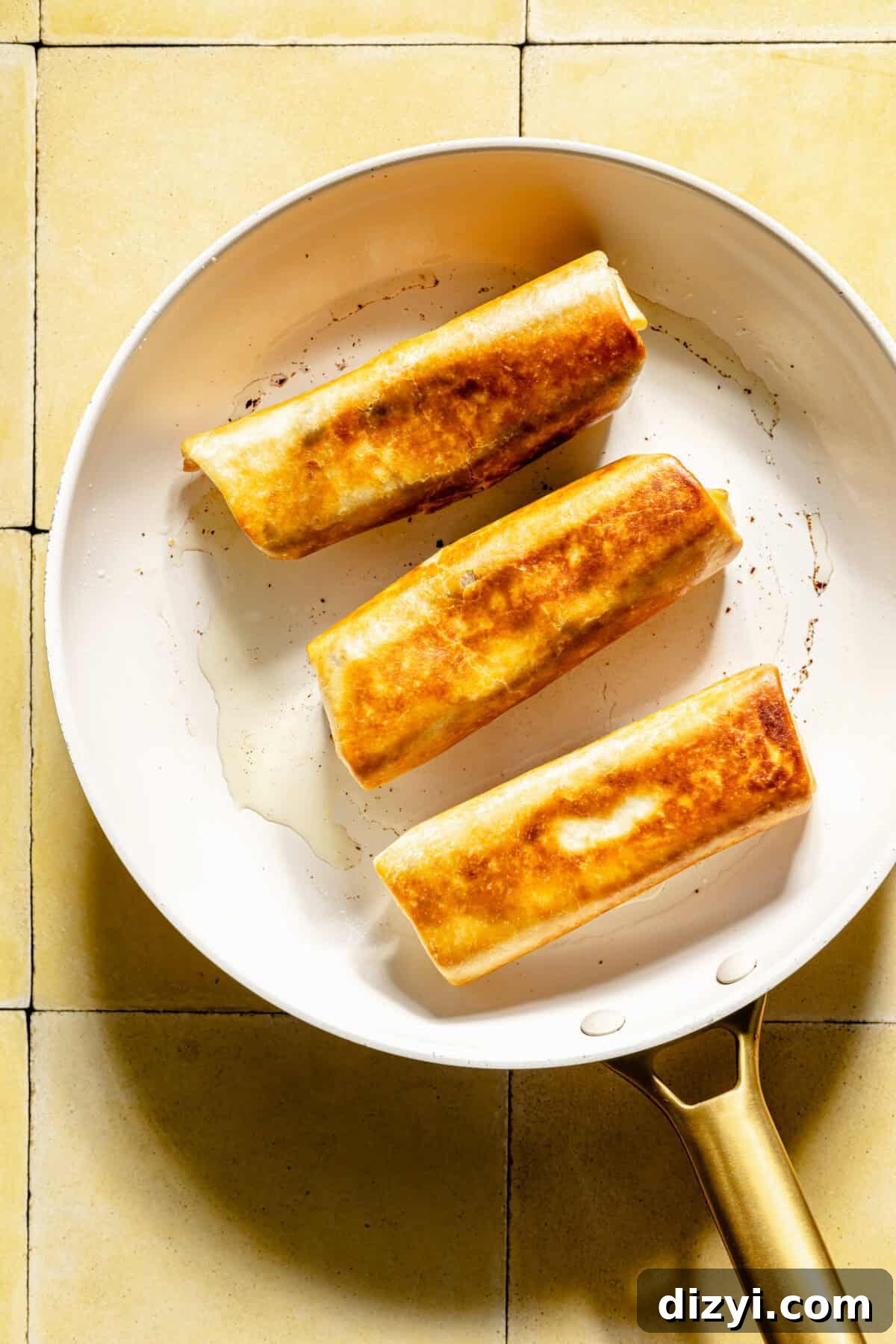 Crispy Southwestern Egg Rolls with Avocado Ranch Dip 5 Southwestern Egg Rolls frying in a skillet.