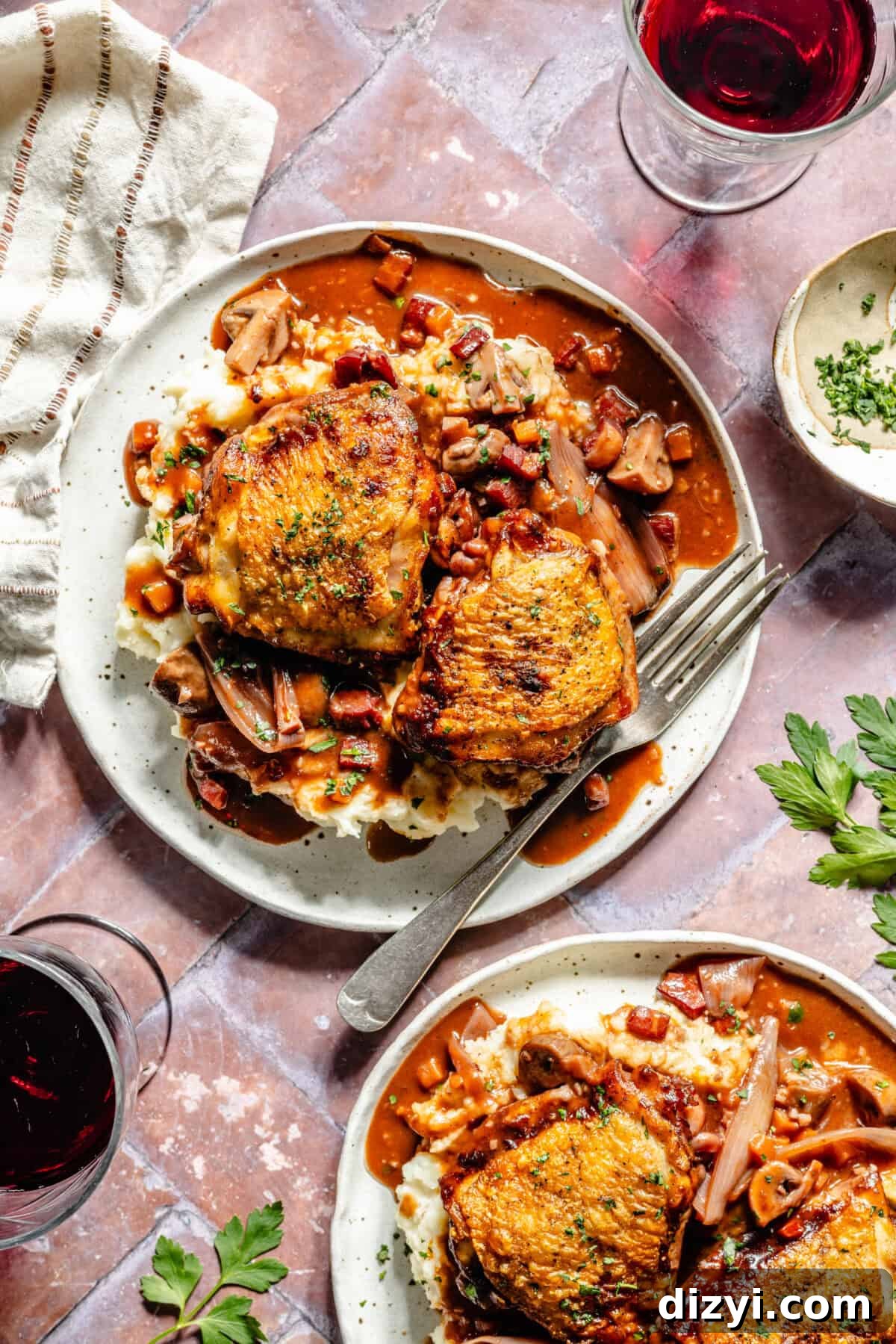 Coq Au Vin plated with red wine in the corner.