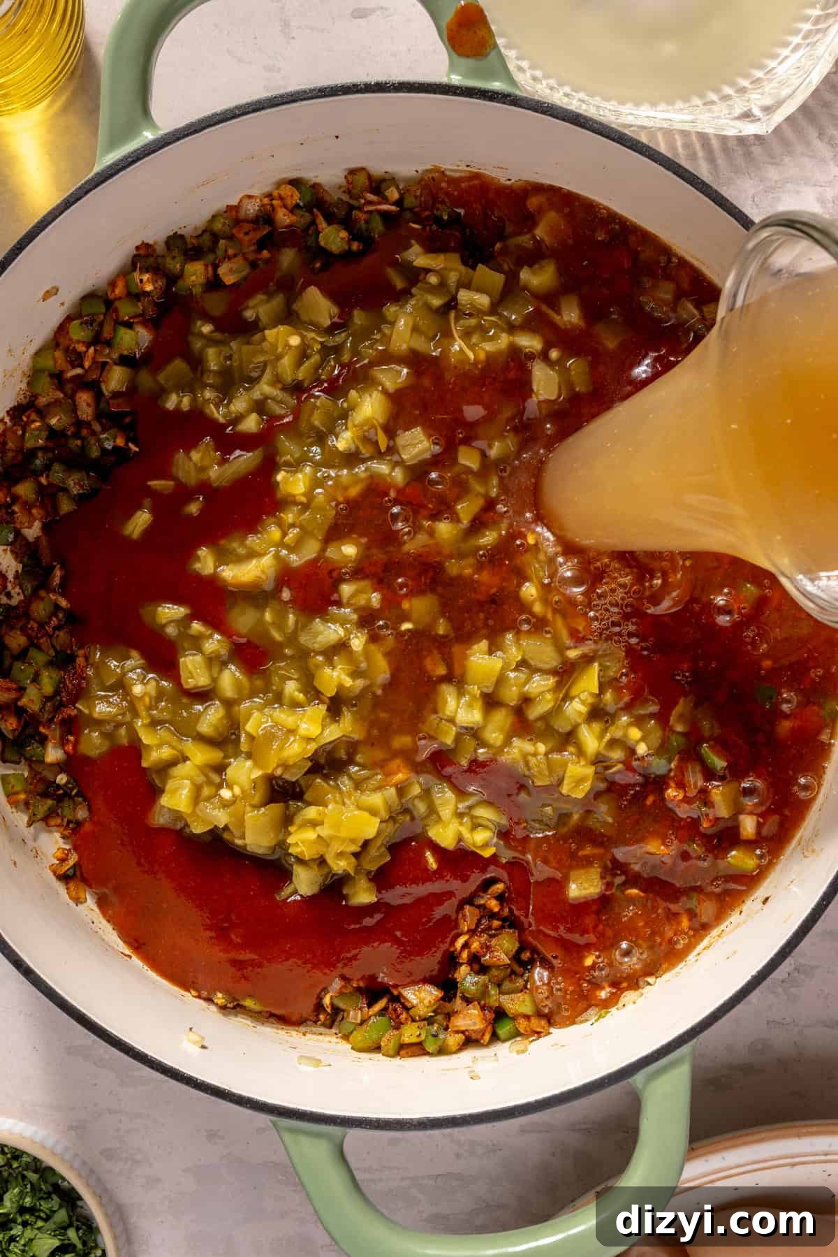Broth pouring into Chicken and Rice Enchilada Soup.