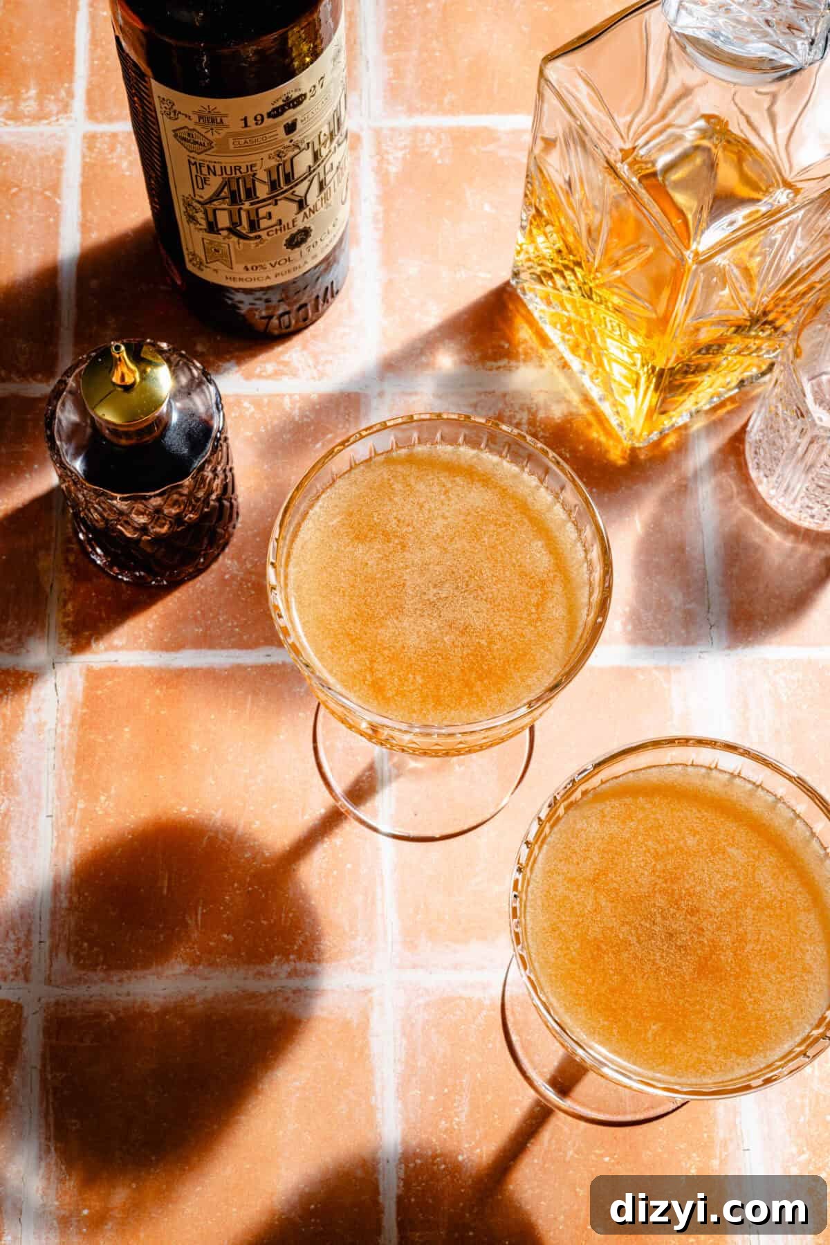 La Palabra in two glasses with liquour in background.