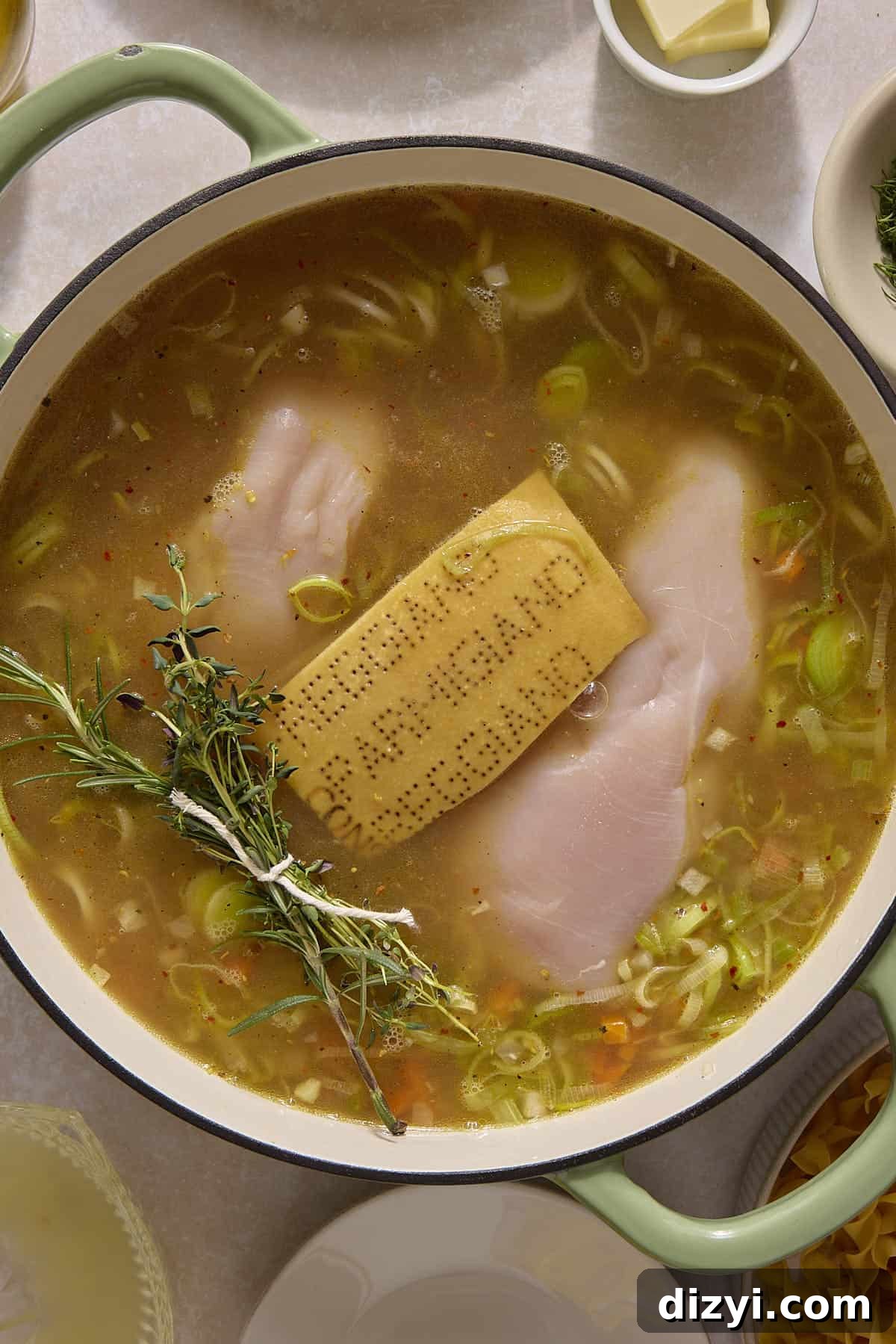 Classic Chicken and Leek Noodle Soup Recipe 5 Parmesan rind, raw chicken, and herb bouquet in Chicken and Leek Noodle Soup.
