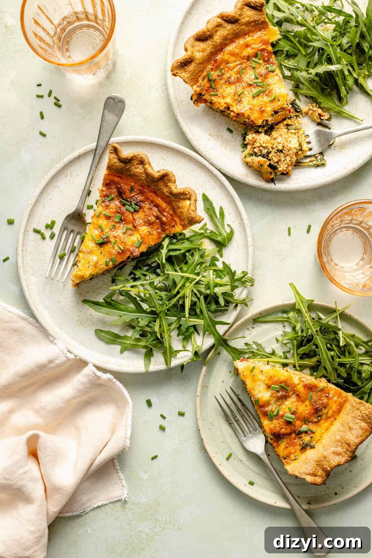Italian Sausage and Arugula Quiche slices on plates with side of arugula.