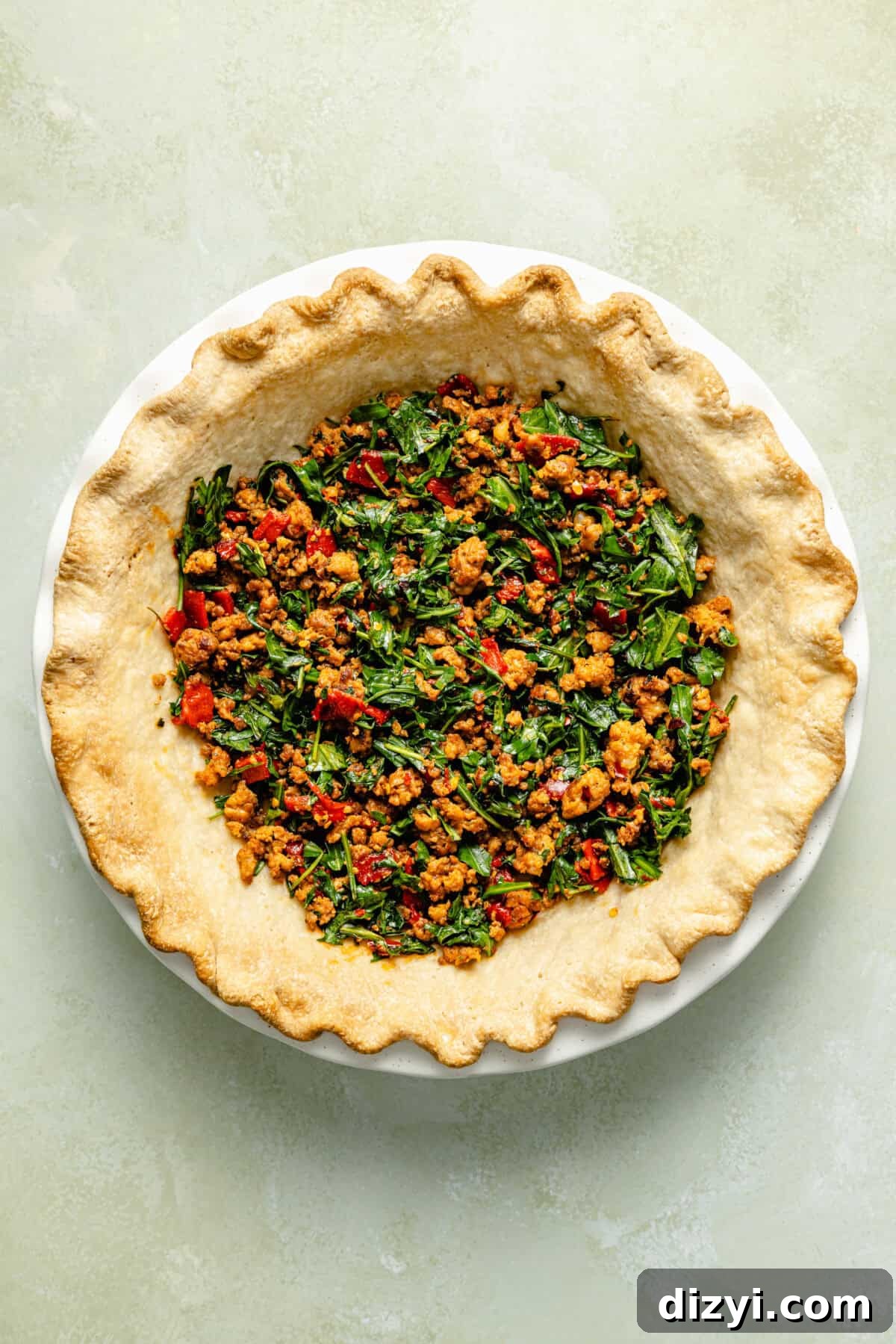 Italian Sausage and Arugula Quiche with just crust and sausage before baking.
