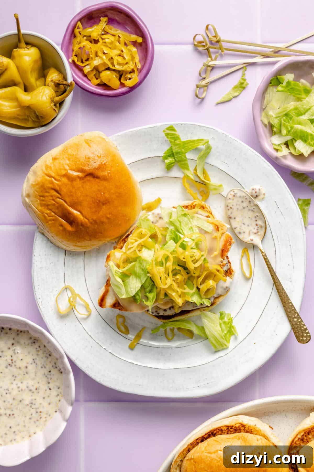 Pepperoncini Grilled Chicken Sandwich getting assembled on plate.