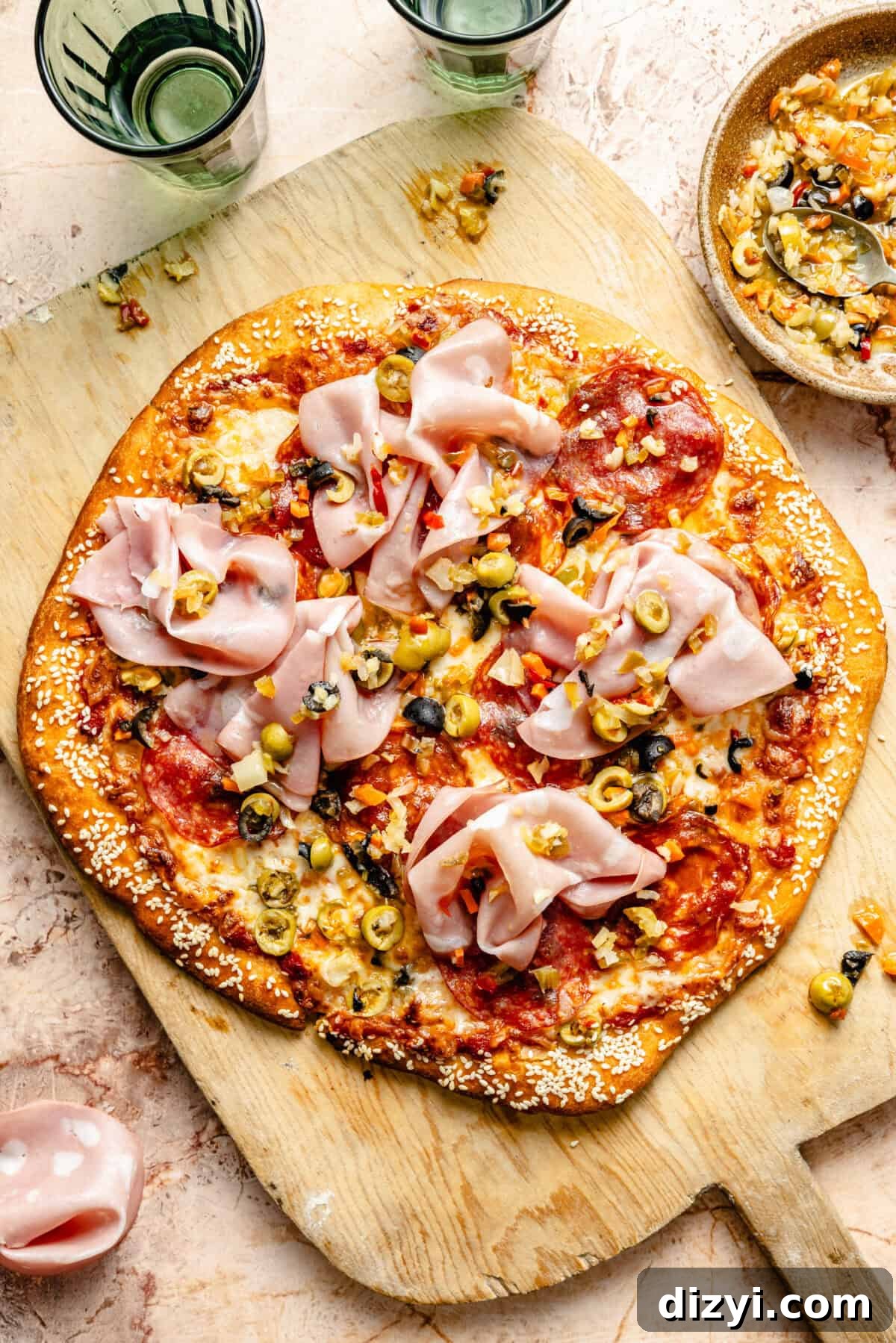 Grilled Muffaletta Pizza Recipe 2 Grilled Muffaletta Pizza on wooden pizza peel.