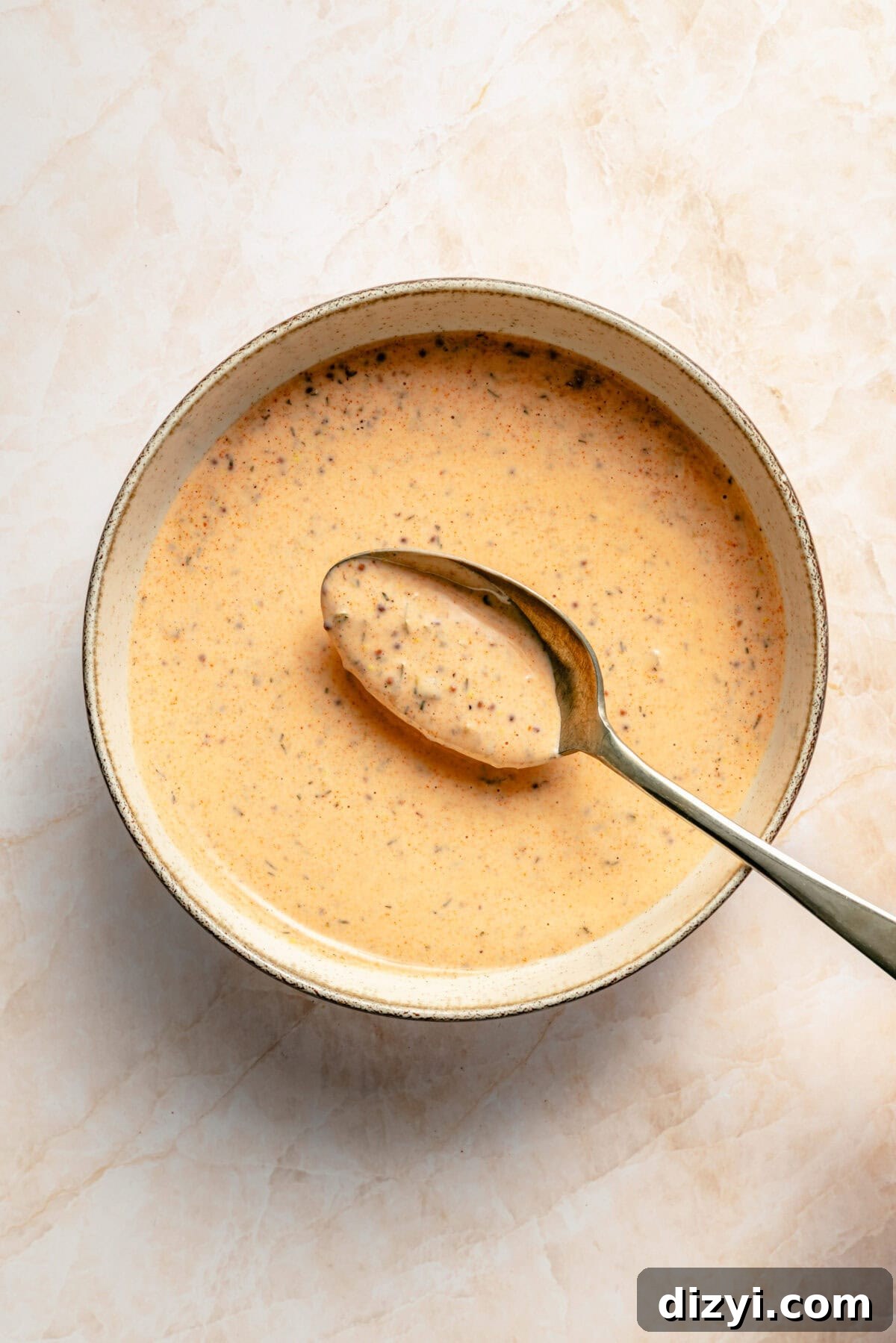 Creamy cajun drizzle mixed in bowl.