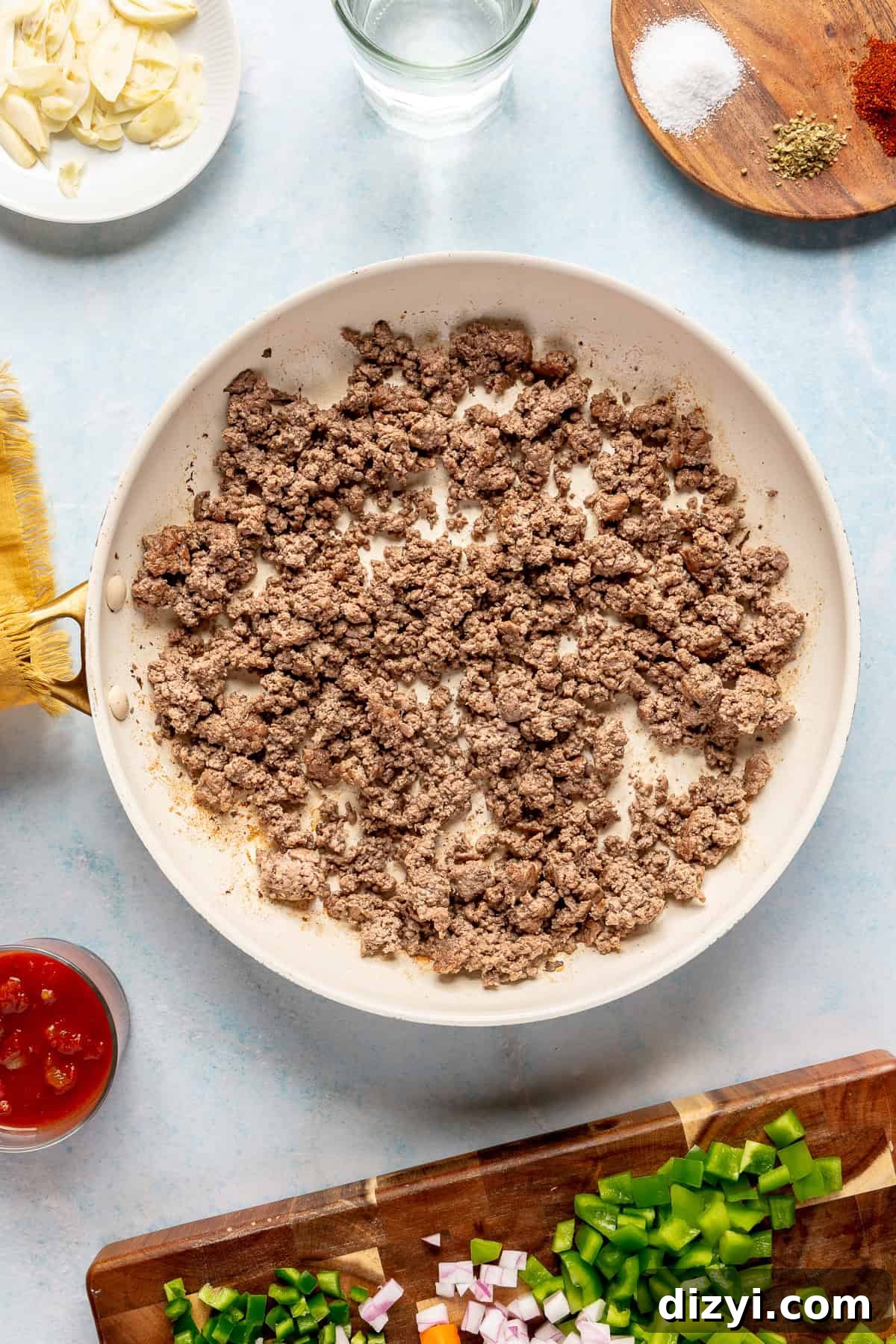 The ground beef for the Crockpot Mexican Picadillo browning in a cream-colored pan.