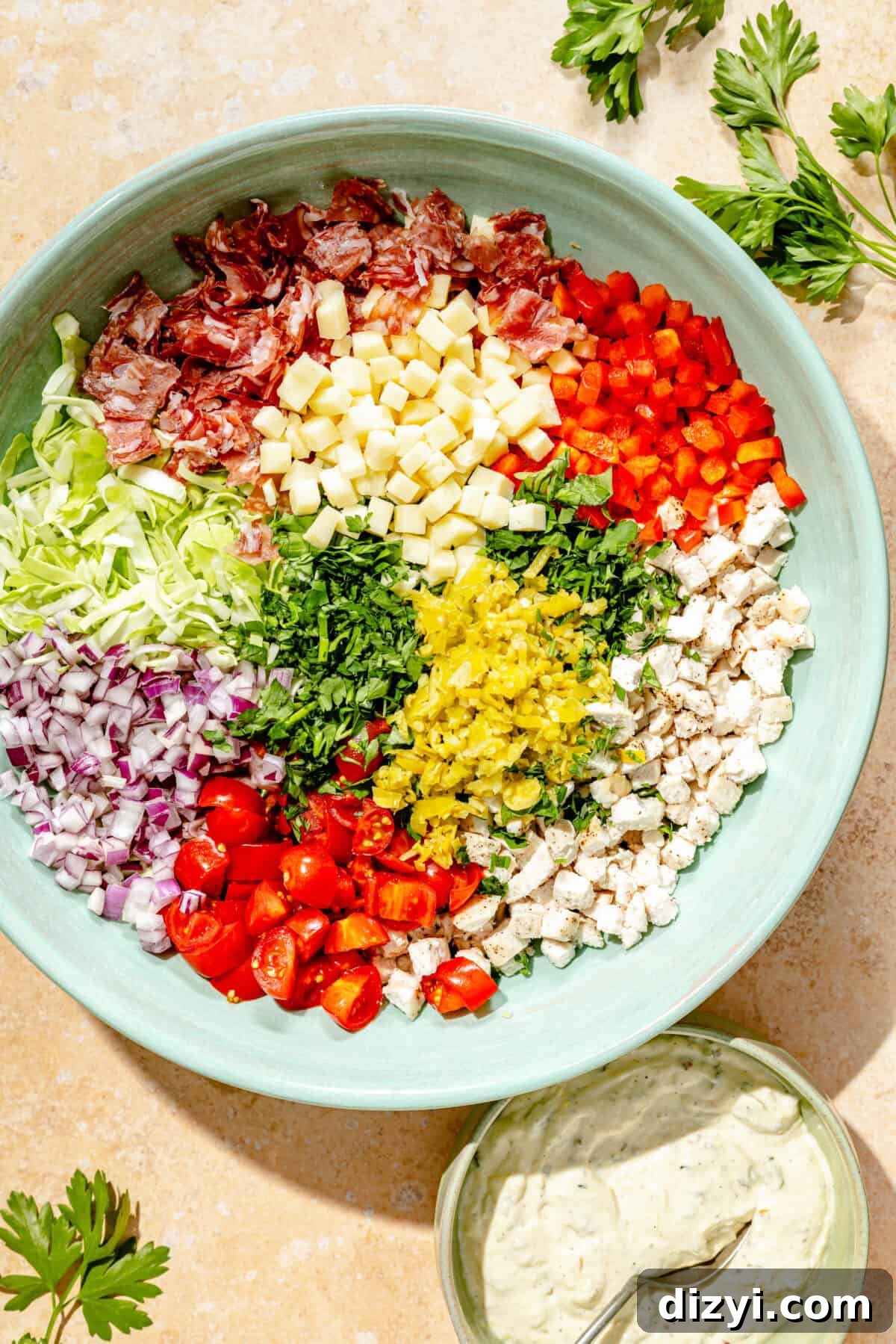 Deli-Style Chopped Chicken Salad Recipe 3 a blue bowl of chopped vegetables including tomatoes, red onions, bell peppers, and herbs