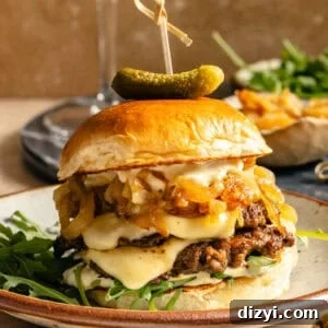 up-close shot of a smashburger with truffle sauce, arugula, cheese, and caramelized onions