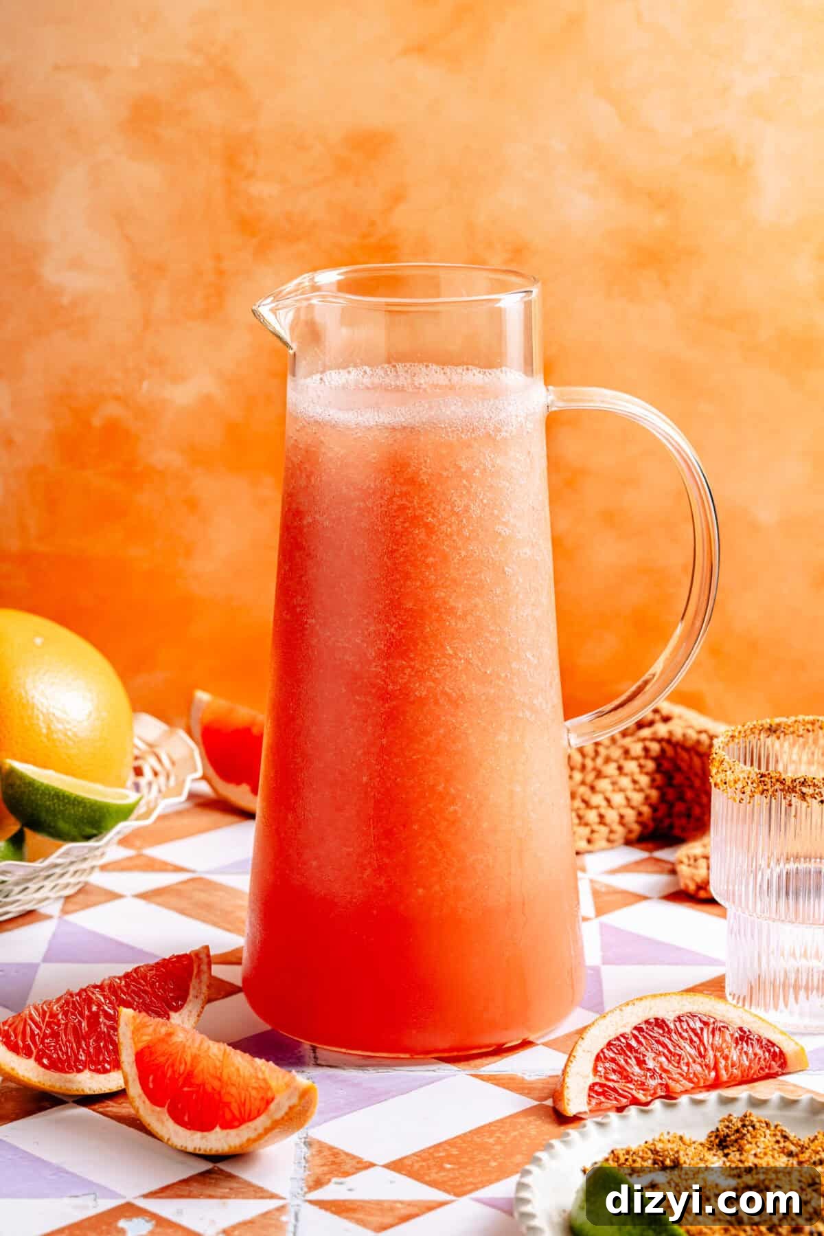 large pitcher of frozen paloma cocktail with citrus wedges 