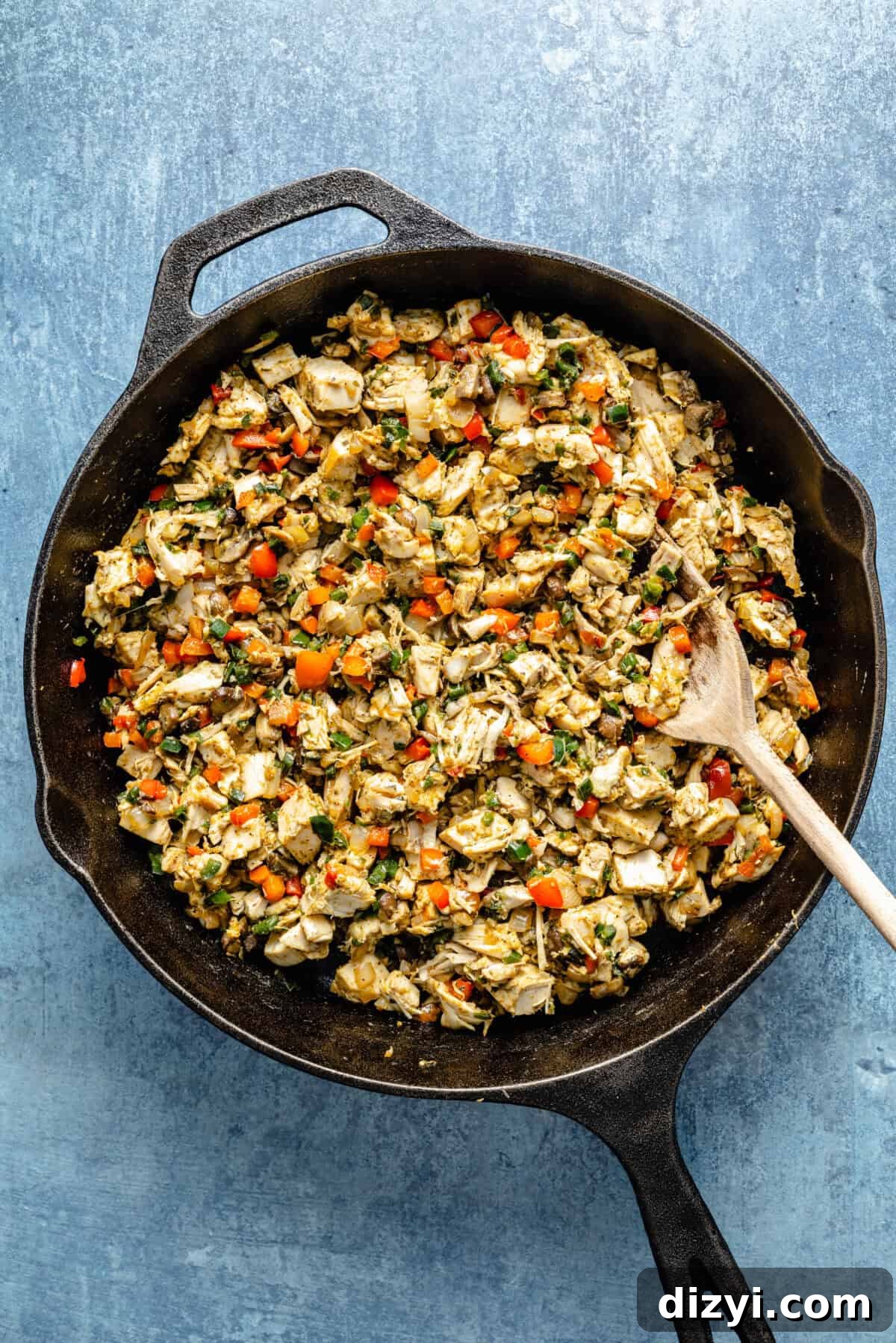 a cast-iron skillet with king ranch chicken casserole on a blue background