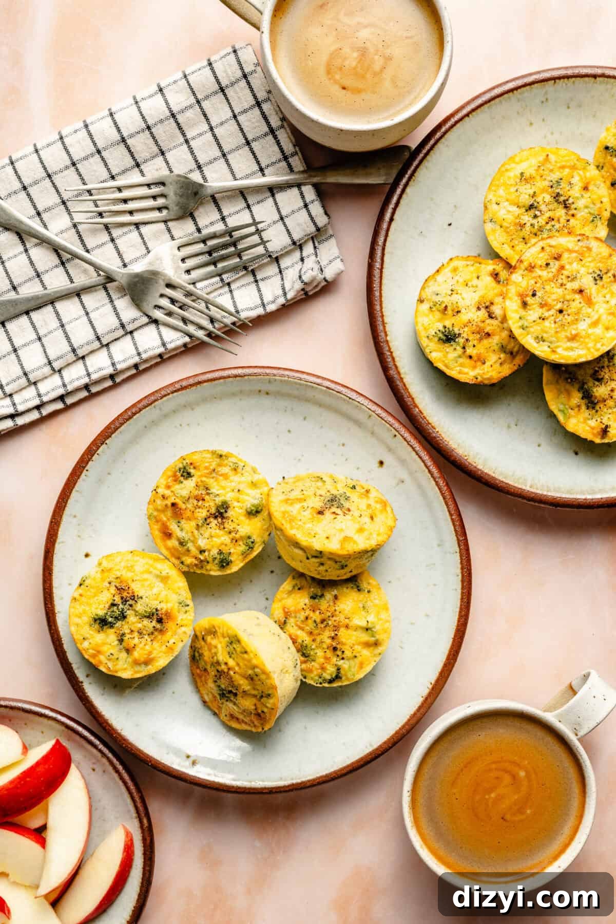 freshly baked broccoli cheddar egg cups on a white porcelain plate with forks and coffee mugs
